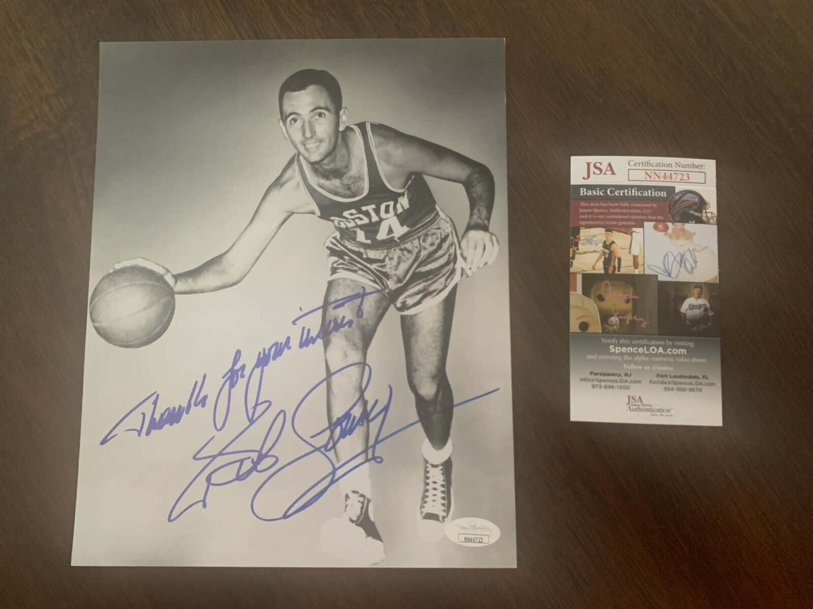 NBA運動員鮑勃·庫西 壁紙 — 一張簽名黑白照片，籃球運動員Bob Cousy身穿波士頓塞爾特人隊制服運球，旁邊有簽名和JSA認證卡在木質表面上。