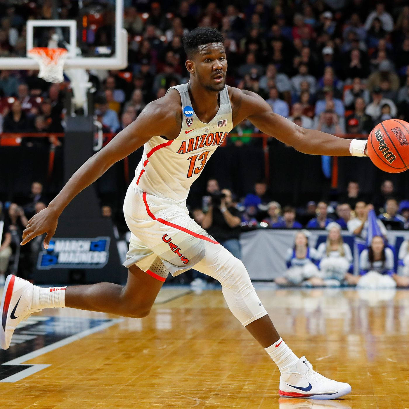 NCAA男子籃球亞利桑那大學野貓隊德安德烈·艾頓 壁紙 — 一名身穿亞利桑那球衣的籃球運動員在明亮的場館燈光下，於三月瘋狂比賽中運球。