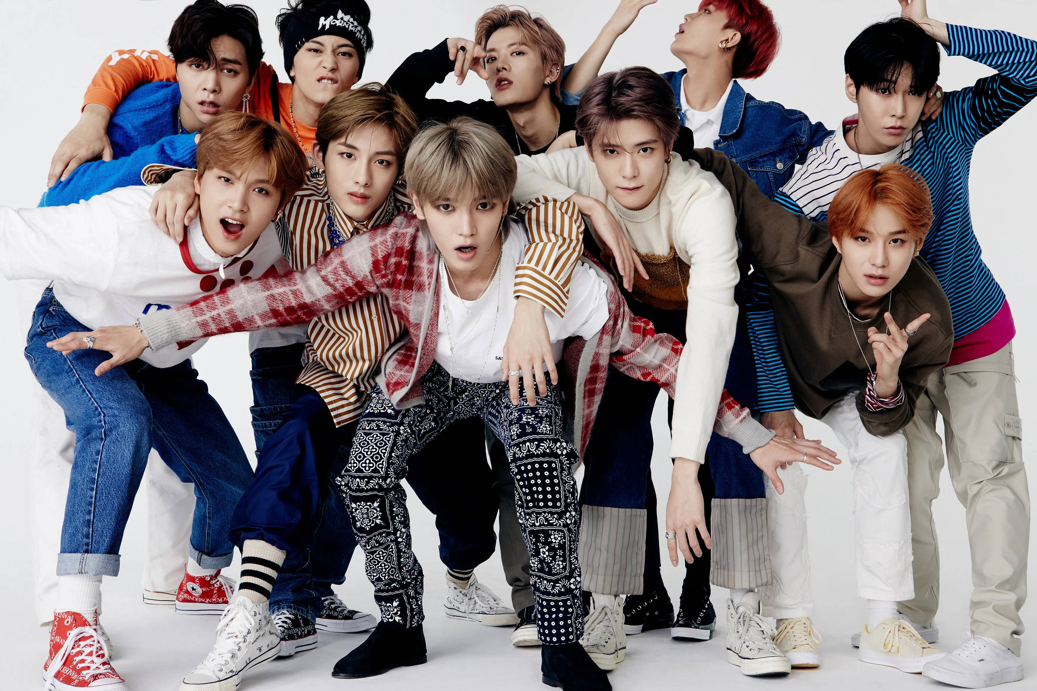 NCT 127 Regular專輯預告圖 壁紙 — 一群充滿活力的年輕男子穿著色彩繽紛的街頭服飾，在純白色背景前擺出俏皮的姿勢。