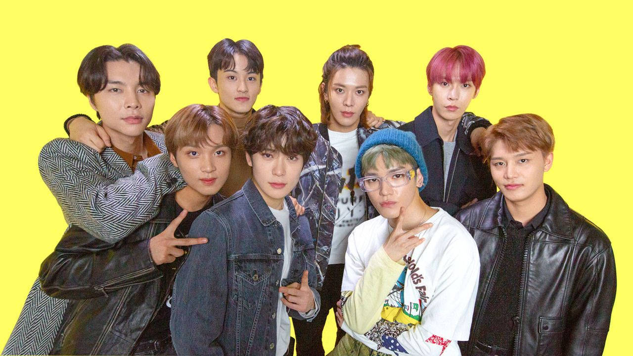 NCT 127 珍珠新香檳色系團體照 壁紙 — 七位時尚年輕男士在明亮的黃色背景前自信擺姿勢，髮色各異，穿著休閒街頭服飾。