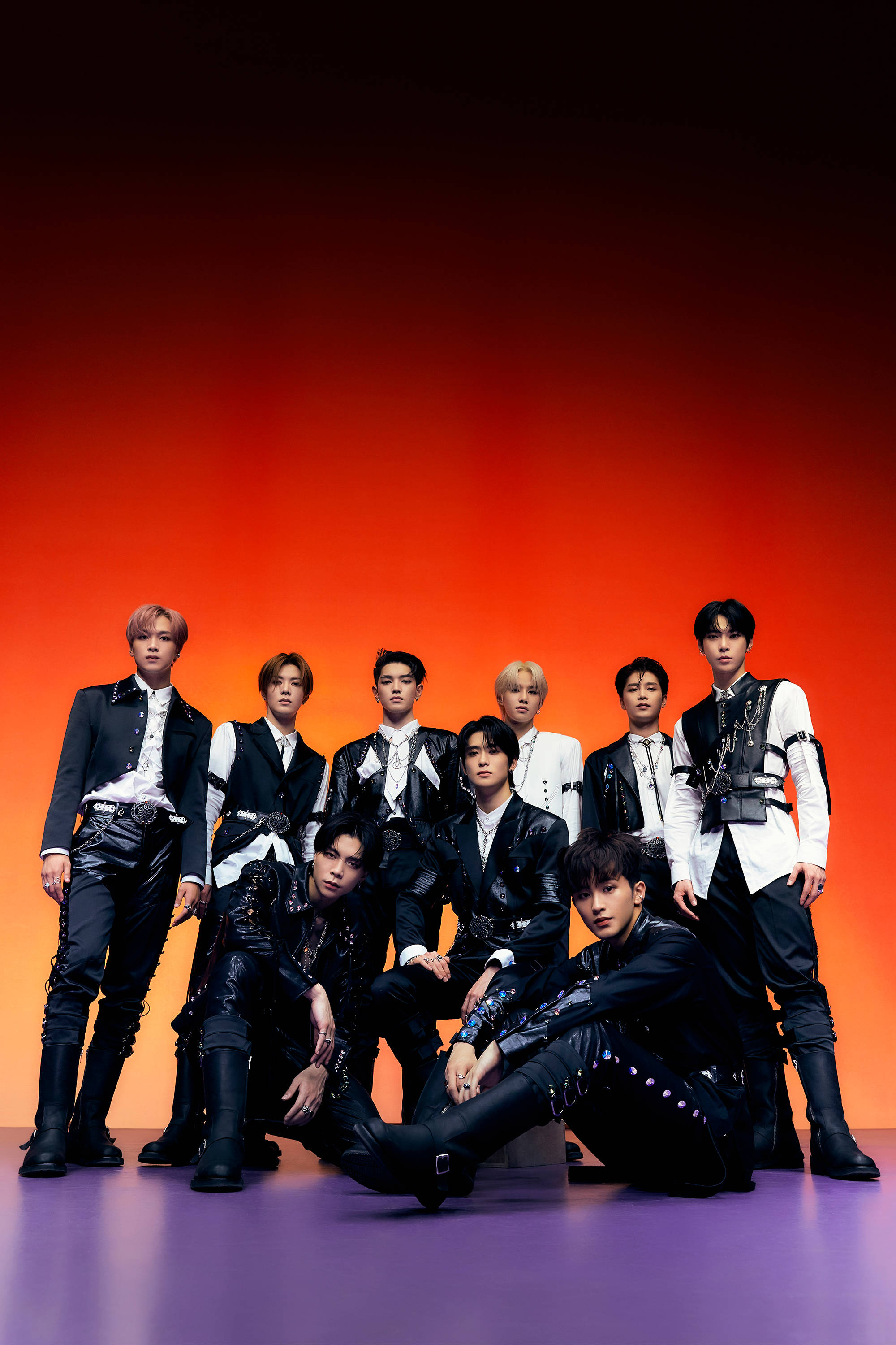 NCT 127《Sticker》專輯黑白造型照 壁紙 — 七位時尚男士身穿黑白服裝，在帶有紫色地板的火熱橙色漸變背景前自信地擺姿勢。
