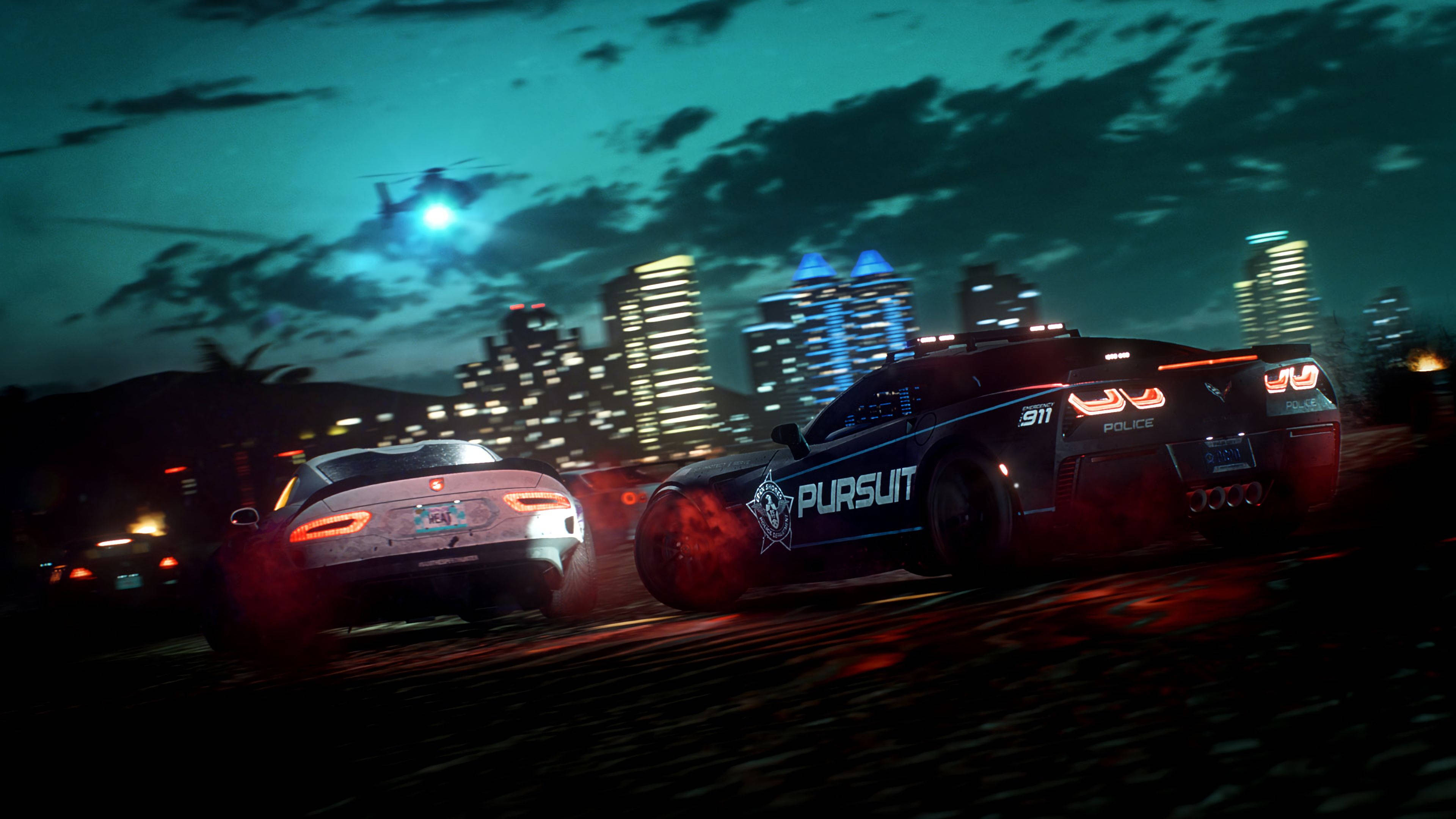 《Need for Speed Heat》夜間警匪追逐 壁紙 — 一輛警車在夜間追逐一輛跑車穿過霓虹燈照亮的城市，頭頂有直升機。