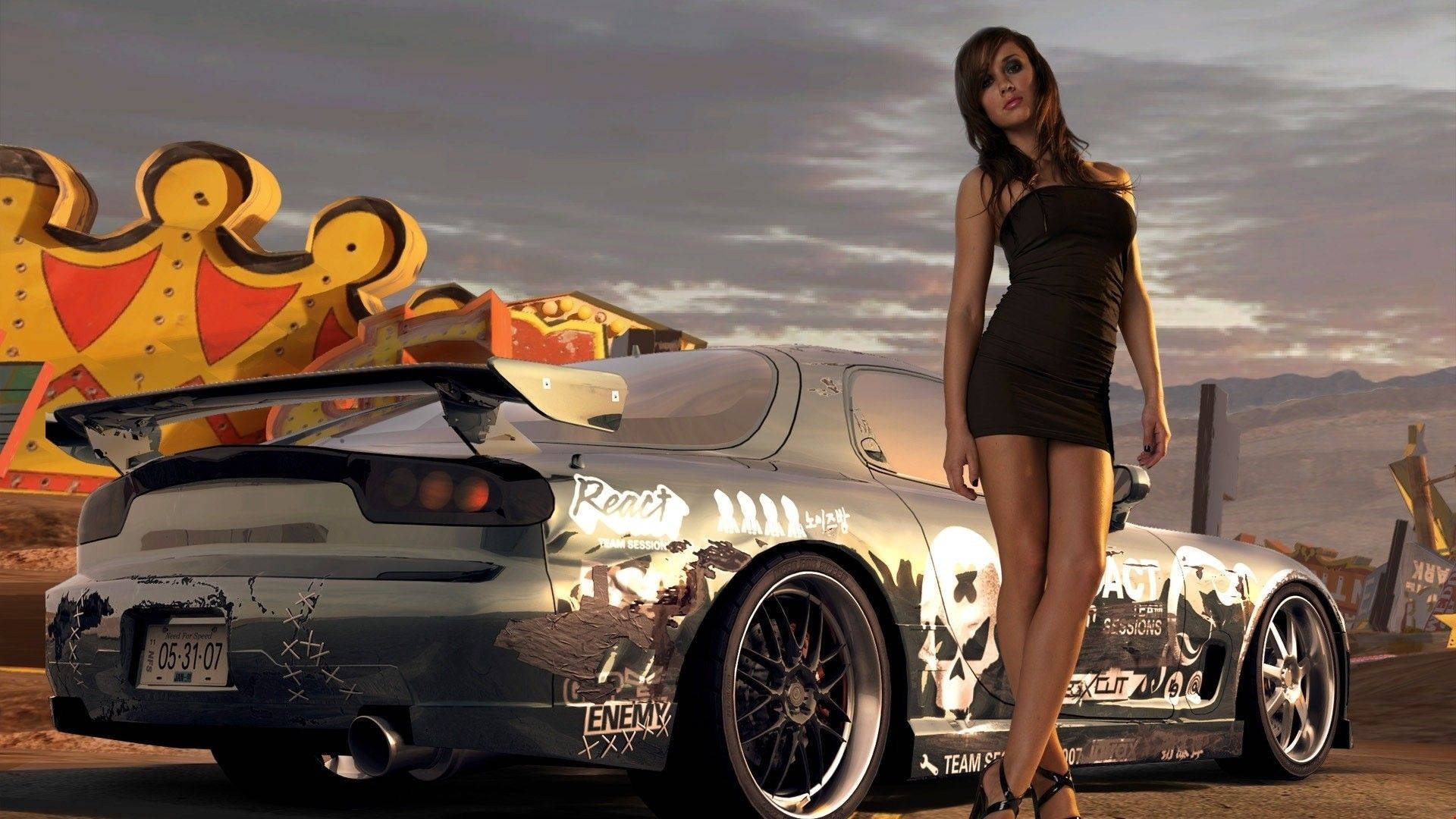 《Need For Speed Heat》車旁模特 壁紙 — 一名身穿黑色連衣裙的女子站在一輛塗滿塗鴉的跑車旁，背景是陰雲密布的沙漠天空和一個巨大的皇冠標誌。