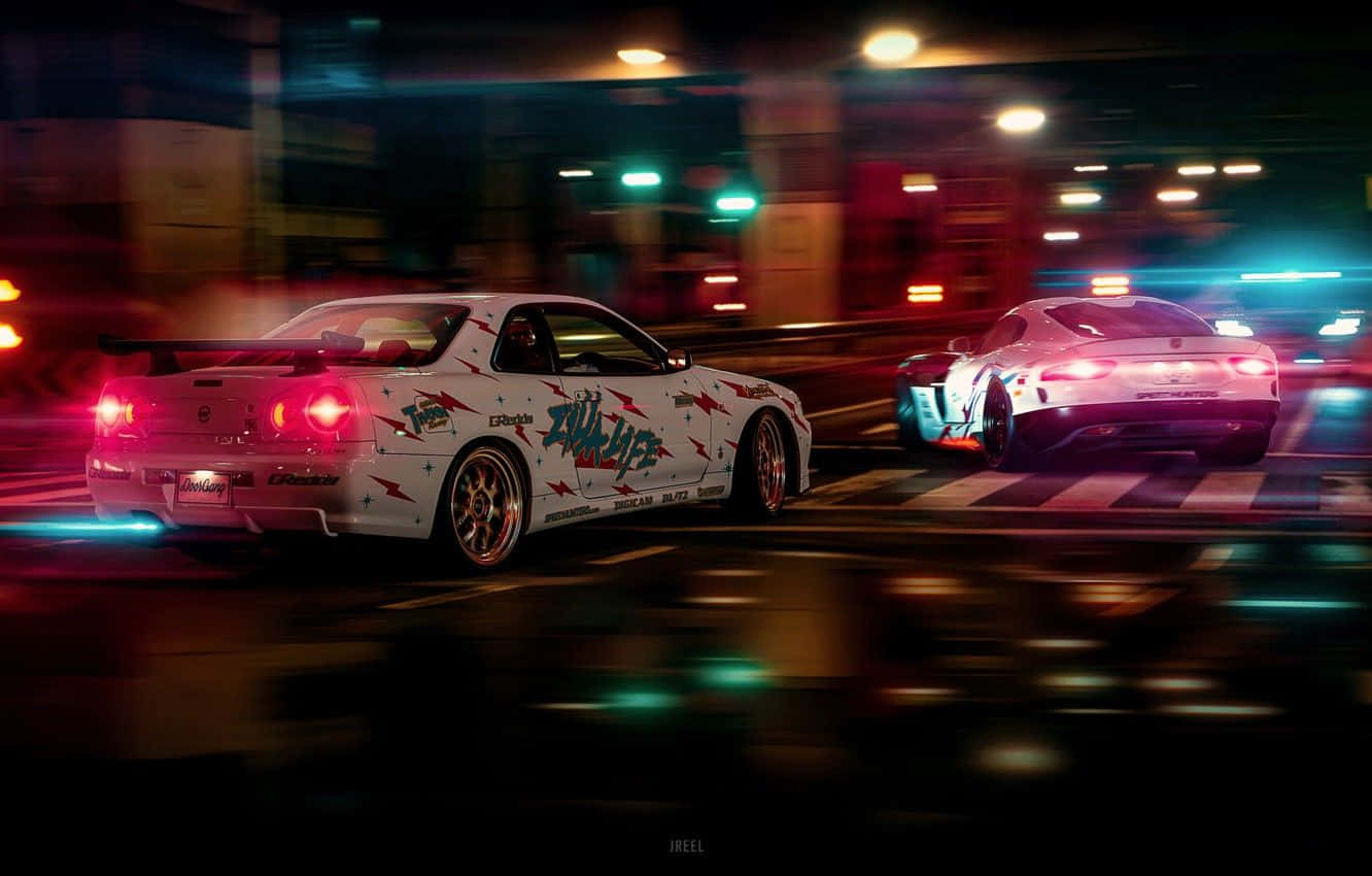《Need For Speed Heat》賽車背景：夜間城市 壁紙 — 兩輛飄移車在夜間穿過霓虹燈照亮的城市街道，帶有動態模糊和發光的燈光。