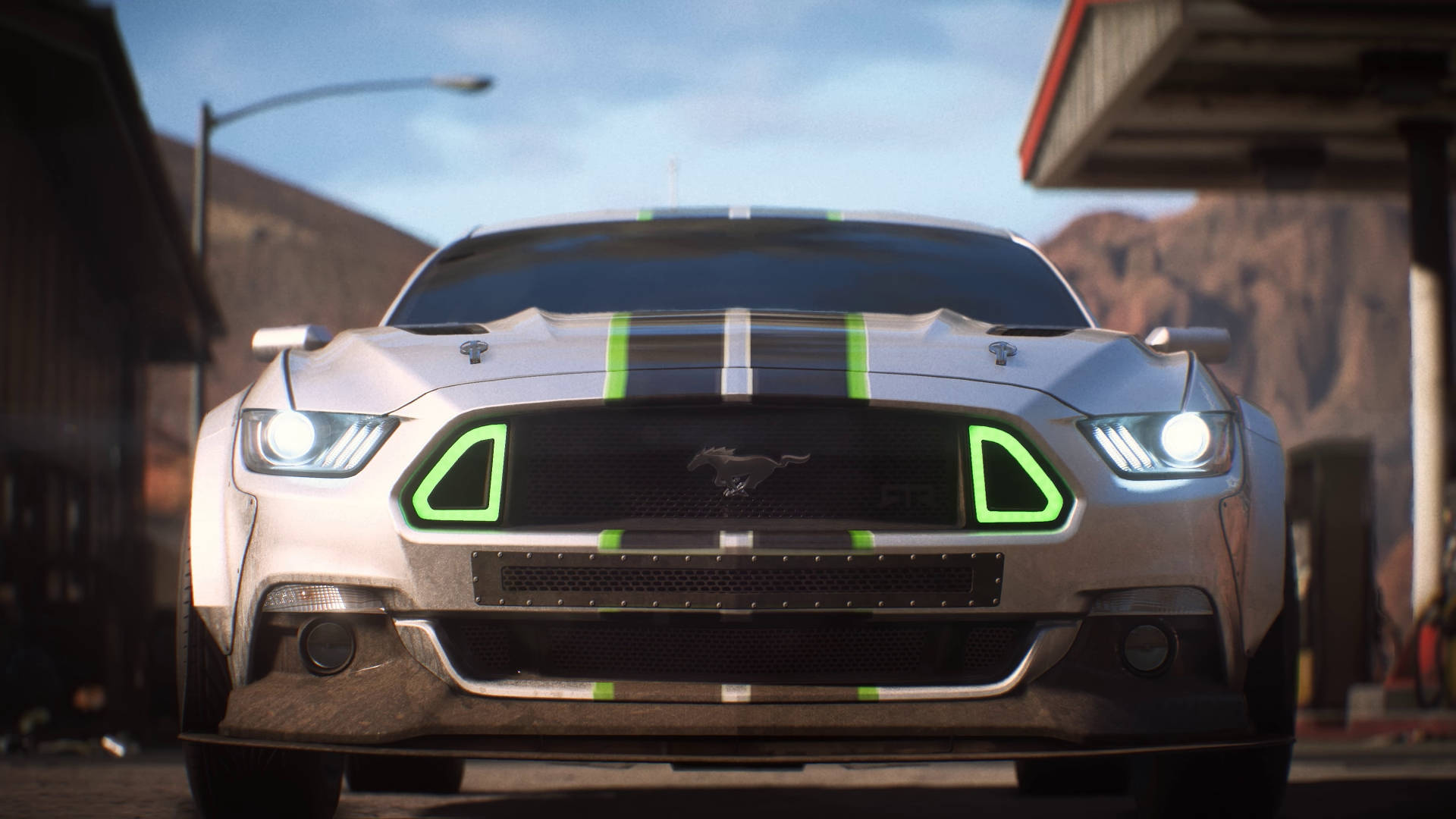 《Need for Speed Payback》銀色野馬前視圖 壁紙 — 一輛銀色福特Mustang GT帶有發光綠色飾邊，在沙漠加油站清澈藍天下向前凝視。
