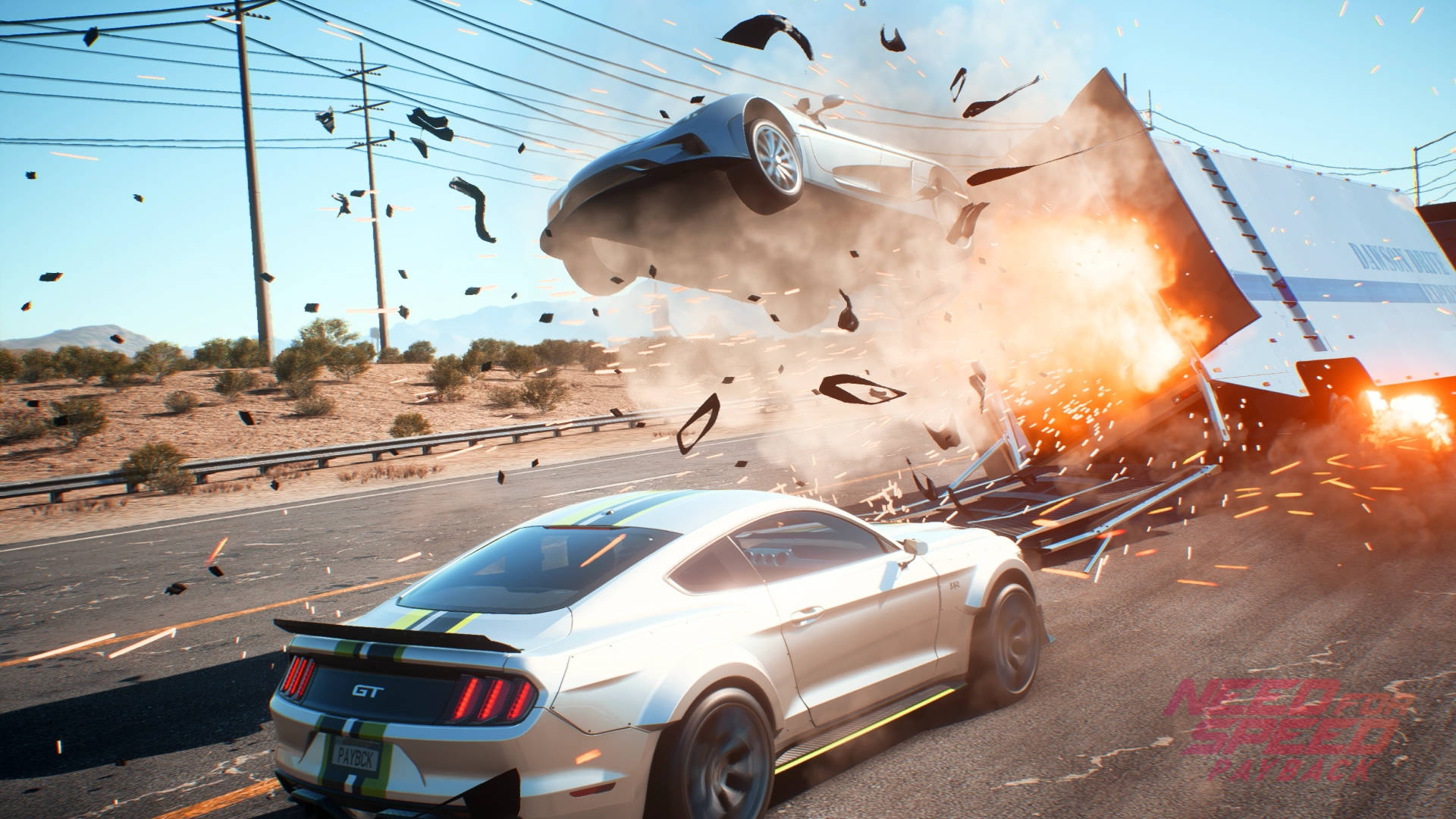 《Need For Speed Payback》賽車撞擊場景 壁紙 — 一輛銀色福特野馬GT在沙漠高速公路的混亂中撞上一輛爆炸的卡車，碎片和火花四濺。