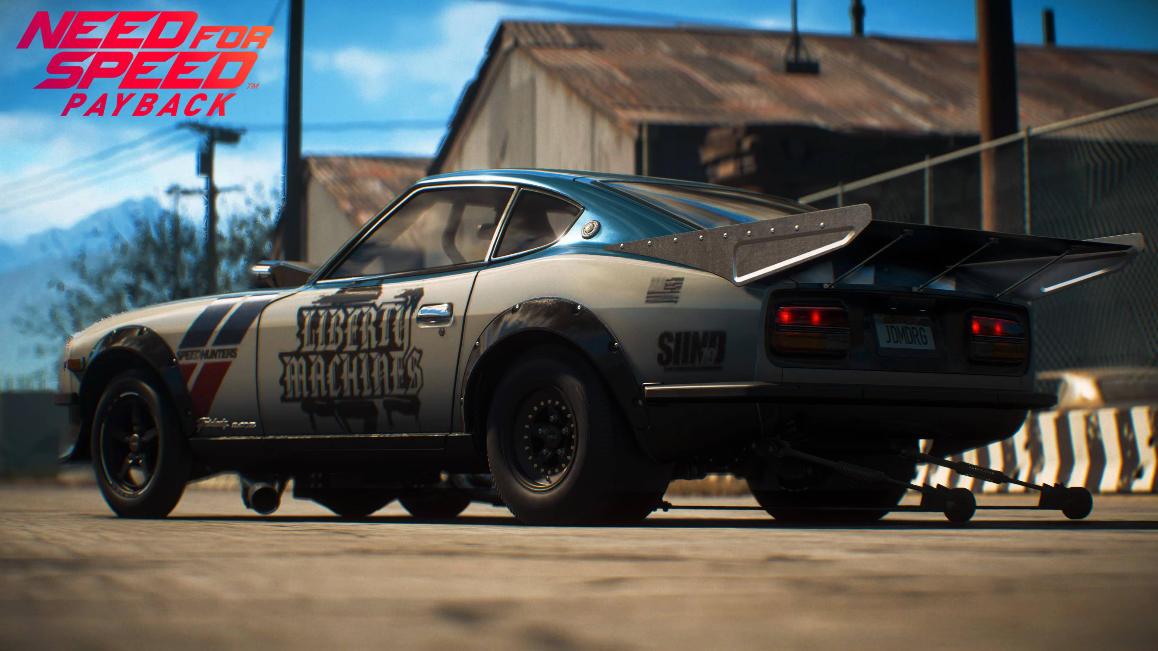 《Need for Speed Payback》日產Fairlady 壁紙 — 一架定製的白色和藍色賽車，帶有「Liberty Machines」貼花，停在晴朗藍天下的直線加速賽道上。