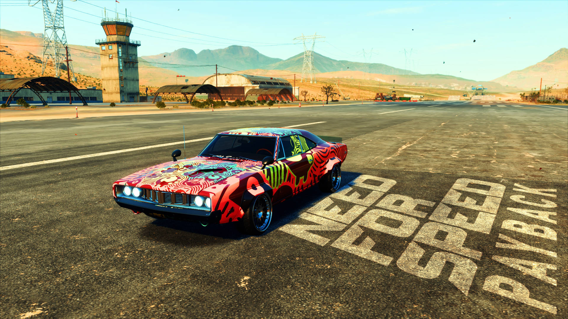 《Need For Speed Payback》彩色道奇Charger 壁紙 — 一架充滿活力的塗鴉肌肉車停在飛機跑道上，瀝青上塗有 'Need for Speed Payback' 字樣。