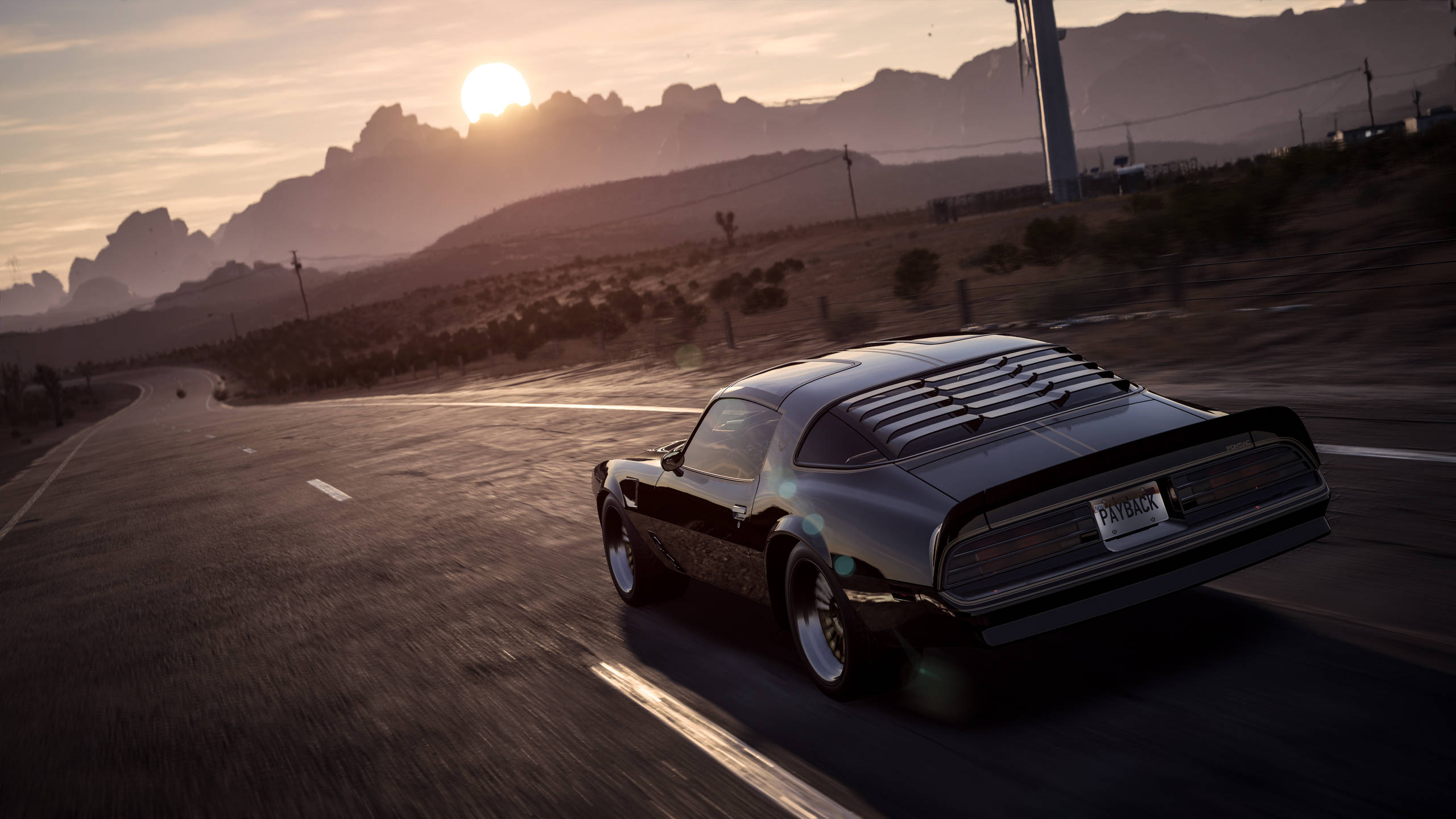 《Need for Speed Payback》龐蒂亞克火鳥 壁紙 — 一輛黑色經典肌肉車在日落時分沿著沙漠公路飛馳，背景是山脈。
