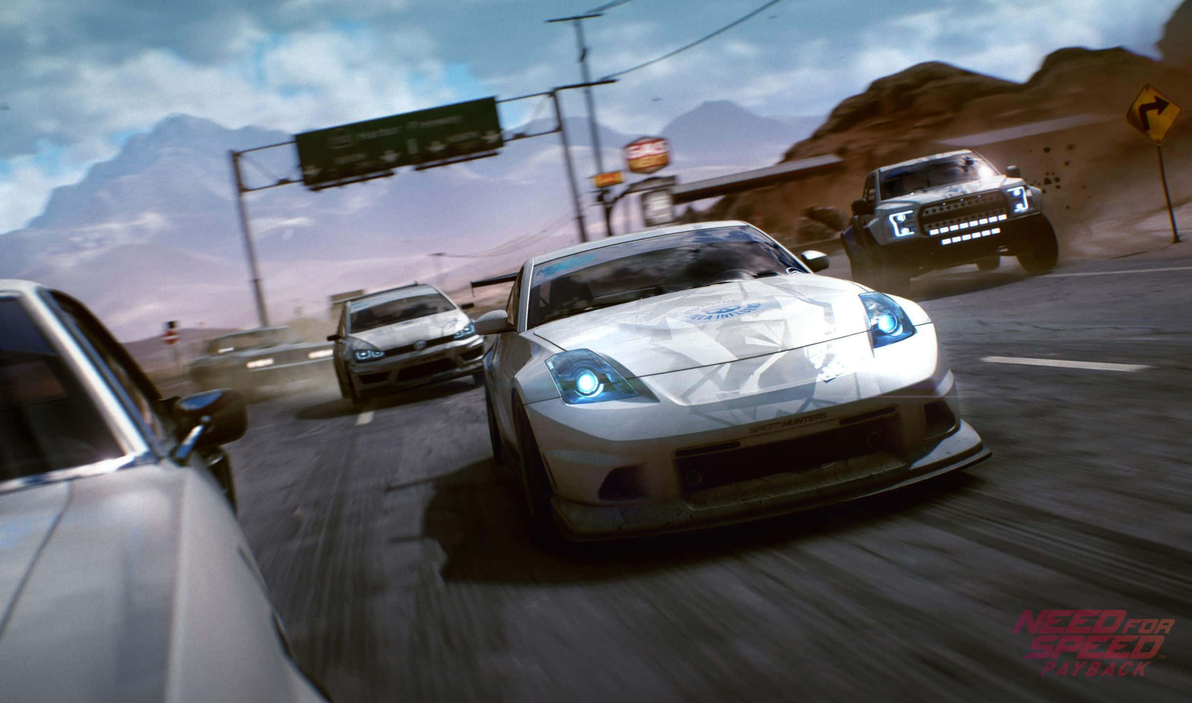 《Need for Speed Payback》中超越對手 壁紙 — 一輛白色跑車在沙漠公路上奔馳，其他車輛在多雲的天空下揚起灰塵。