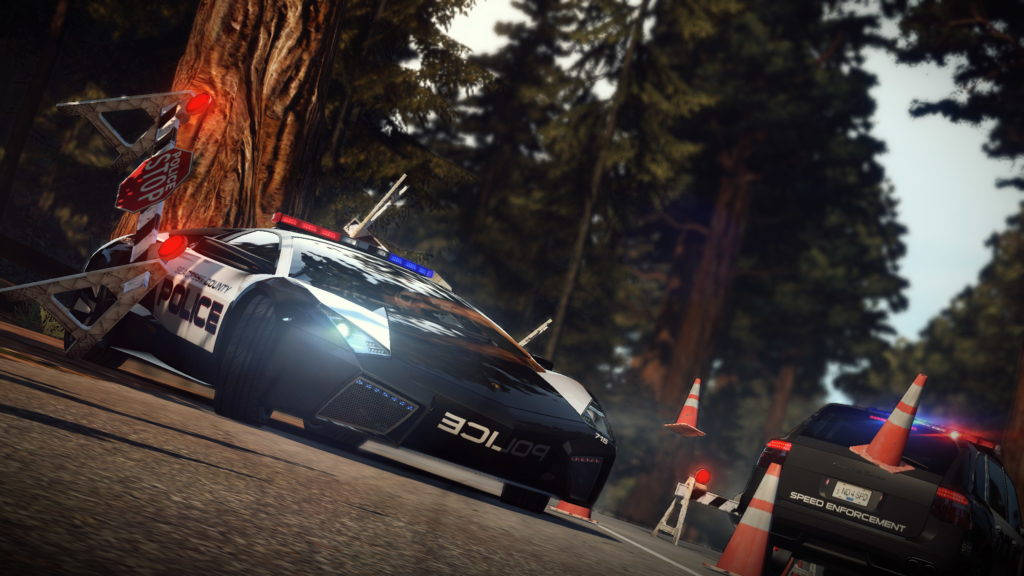 《Need For Speed》警車熱追 壁紙 — 一輛警用跑車在森林道路上撞上一棵樹，伴有閃爍的燈光和交通錐。