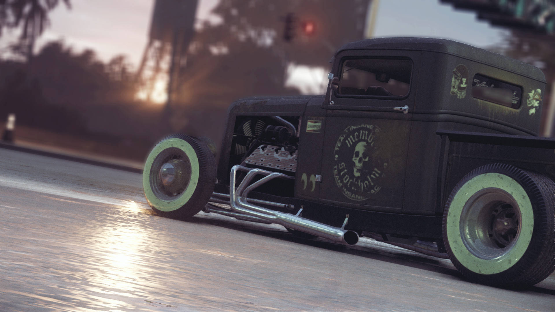 《Need For Speed》黑色Ford Rat Rod 壁紙 — 一輛黑色熱棒車配綠色邊緣輪胎在日落時分在潮濕的街道上飛馳，在路面上投射出金色的光芒。