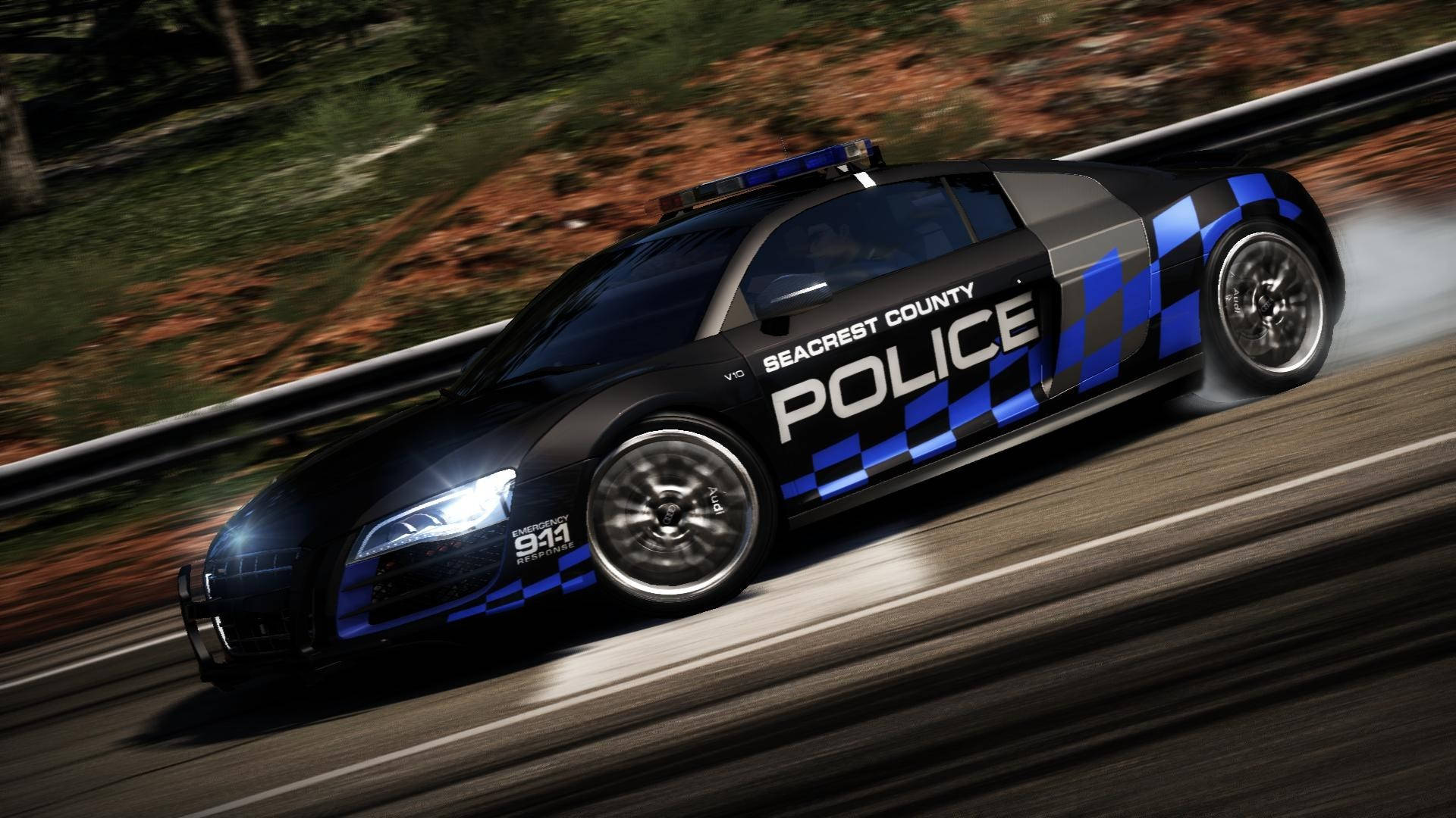 《Need For Speed》黑色Audi警車 壁紙 — 一輛黑藍色的Seacrest County警用跑車在森林道路上以動態模糊效果飄移過彎。