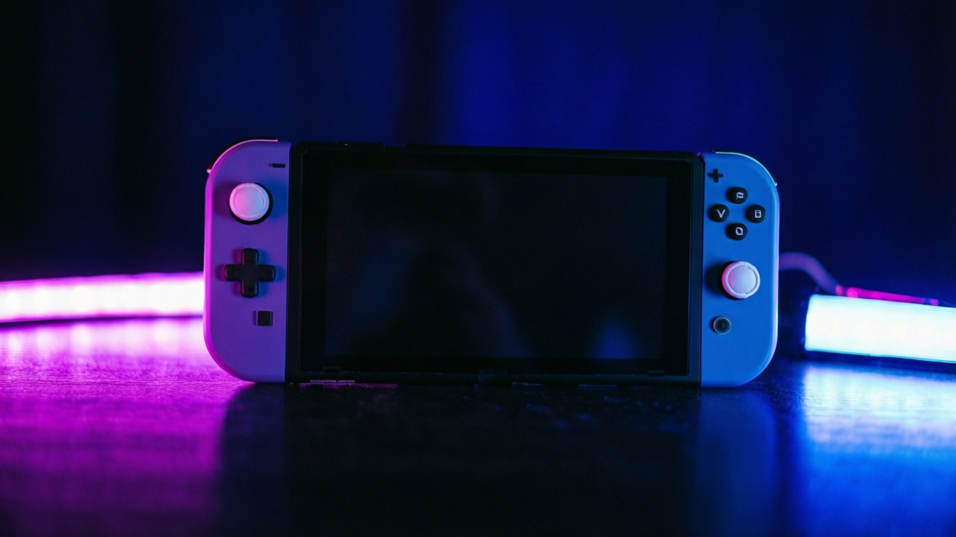 Nintendo Switch主機在黑暗表面上被紫色和藍色霓虹燈照亮