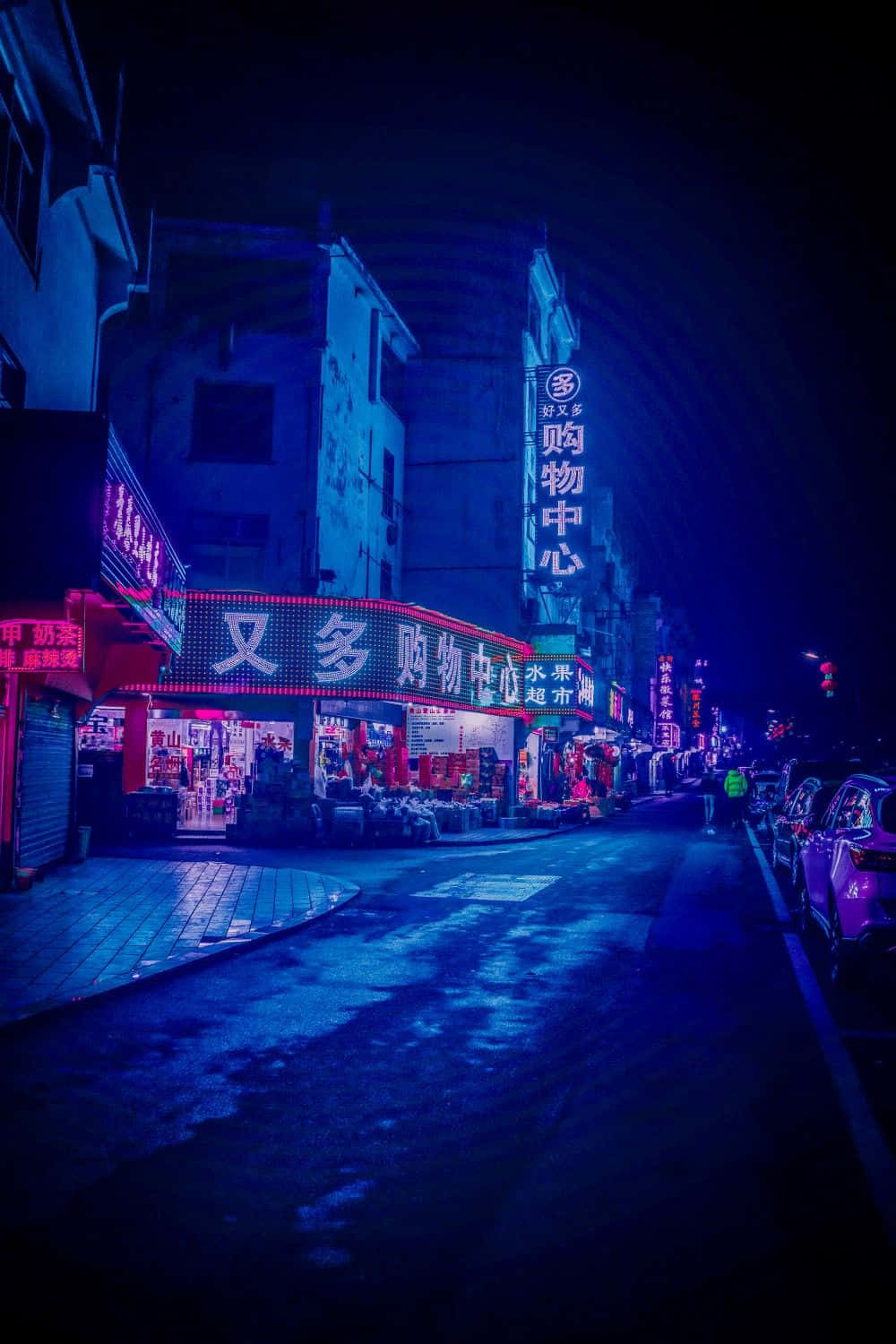  壁紙 — 夜晚一條霓虹燈照亮嘅城市小巷，發光招牌喺黑暗天空下嘅濕漉漉路面反射。