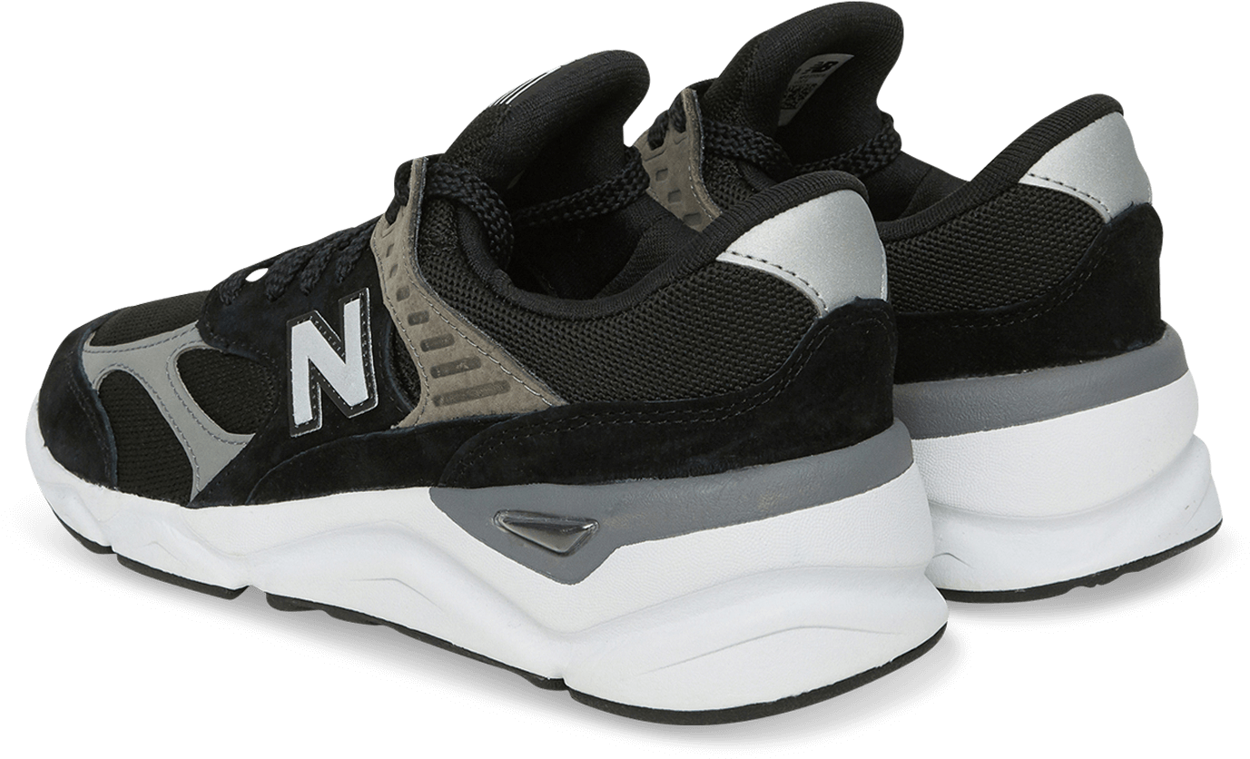 黑白New Balance運動鞋 壁紙 — 一對黑色、灰色和白色的New Balance運動鞋，以側面輪廓展示在純黑色背景上。