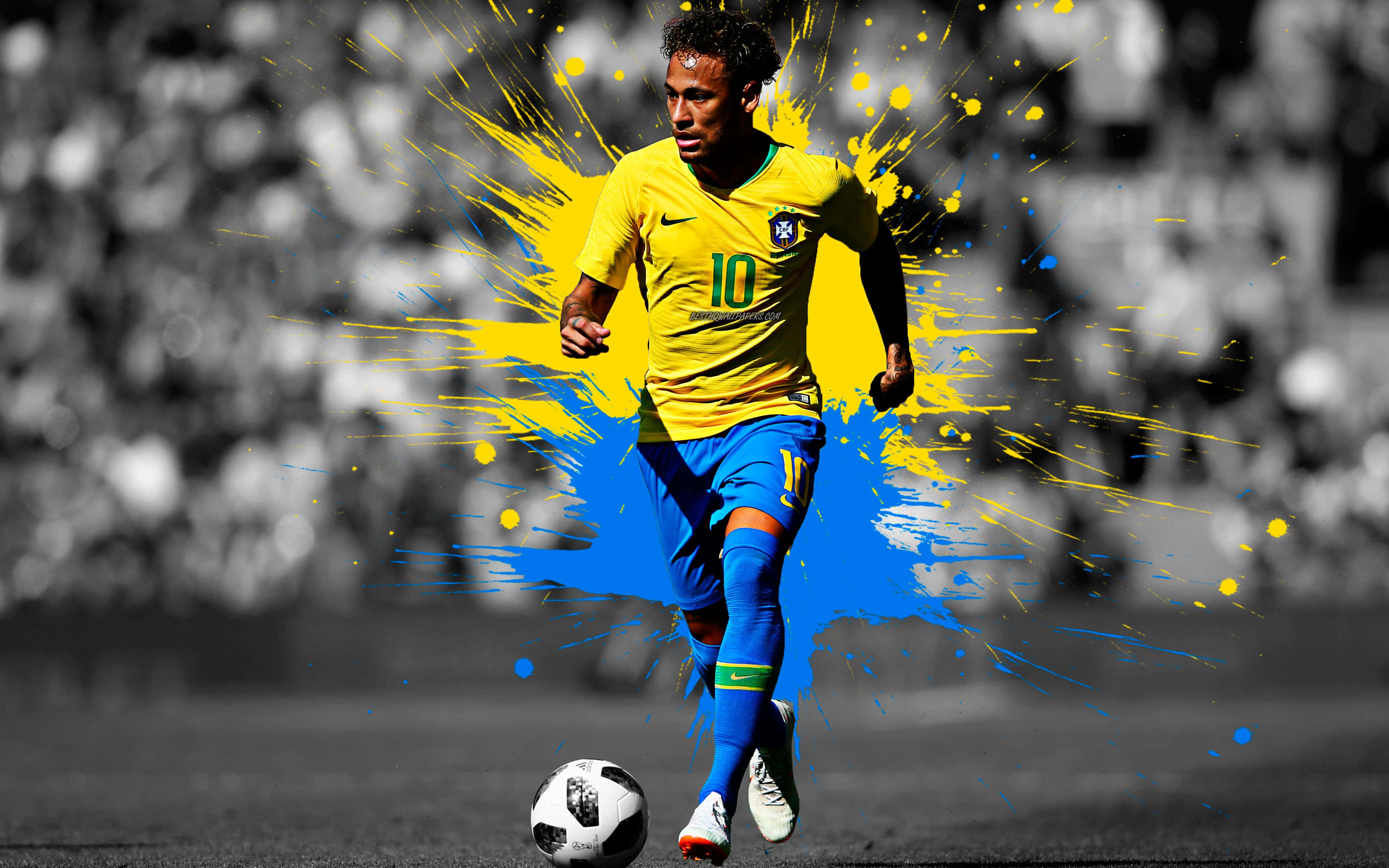 足球員 Neymar 照片 壁紙 — 足球員尼馬正在運球，周圍爆發出充滿活力的黃色和藍色油漆飛濺，背景是黑白球場。