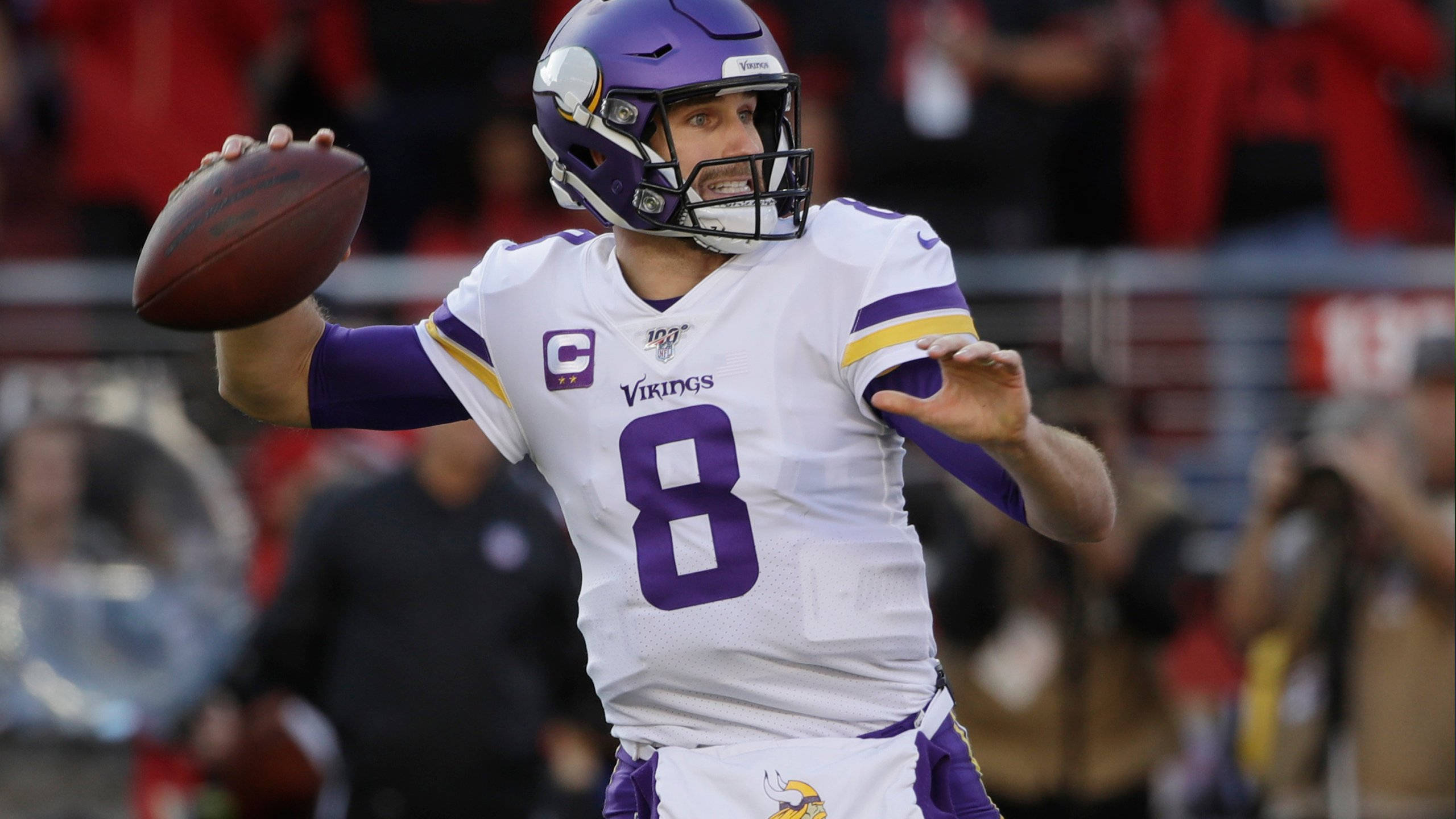 NFL 8號柯克·庫西恩斯 壁紙 — 一名身穿白色和紫色球衣的明尼蘇達維京人四分衛在比賽中準備擲出橄欖球。