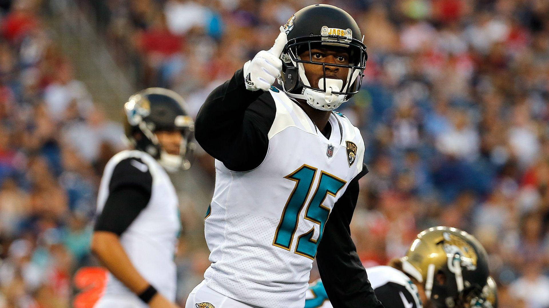 NFL 預季賽 阿倫·羅賓遜 壁紙 — 一名身穿白色和青綠色球衣的傑克遜維爾美洲虎隊美式足球員在比賽中向觀眾豎起大拇指。