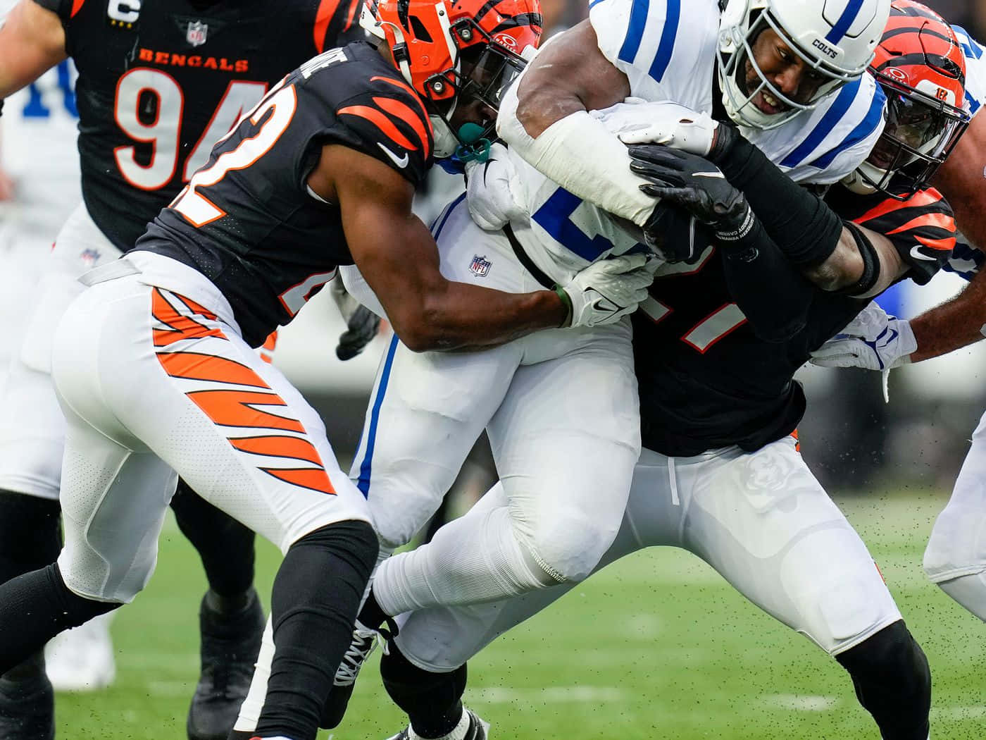  壁紙 — NFL 美式足球激烈攔截，孟加拉虎隊與小馬隊球員在場上展開激烈身體對抗。
