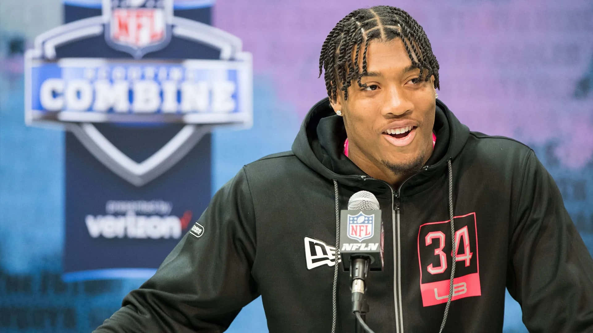  壁紙 — NFL球員身穿黑色連帽衫，號碼34，在NFL選秀聯合測試活動中對著麥克風講話。