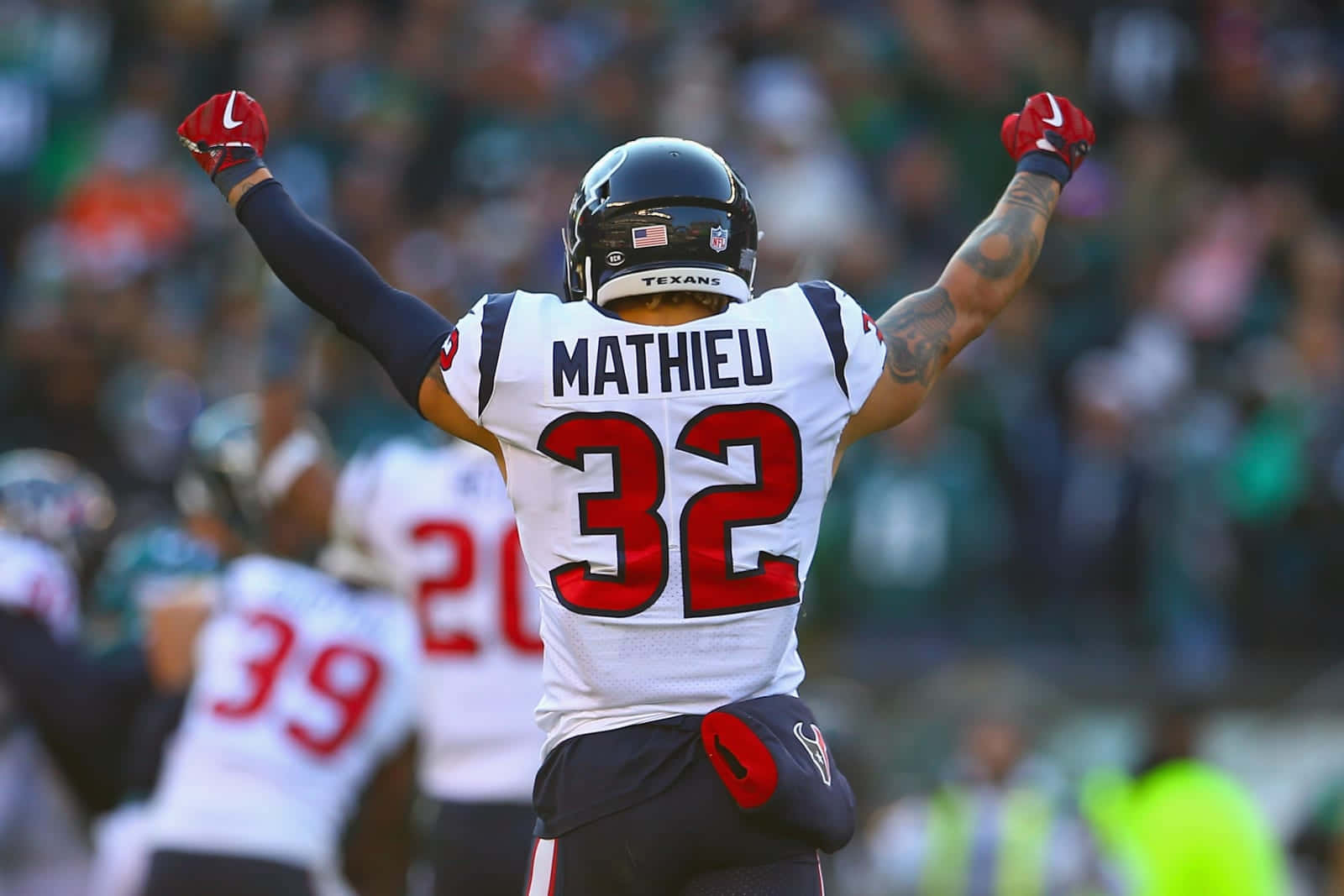 美式足球員 Mathieu 32號在球場上高舉雙臂慶祝。