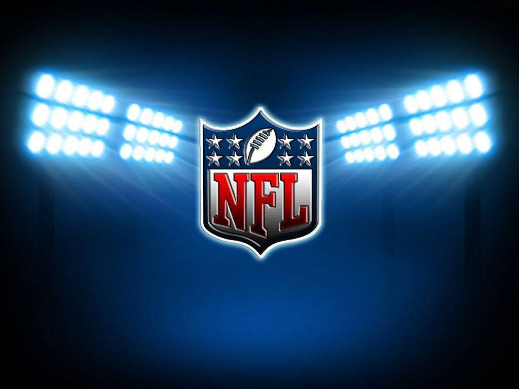 NFL 標誌於聚光燈下 壁紙 — NFL 標誌在深藍色夜空下被明亮的體育場燈光照亮。