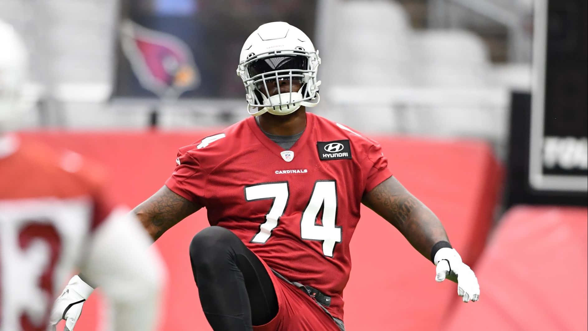 身穿紅色 Cardinals 球衣的足球員在球場上奔跑。