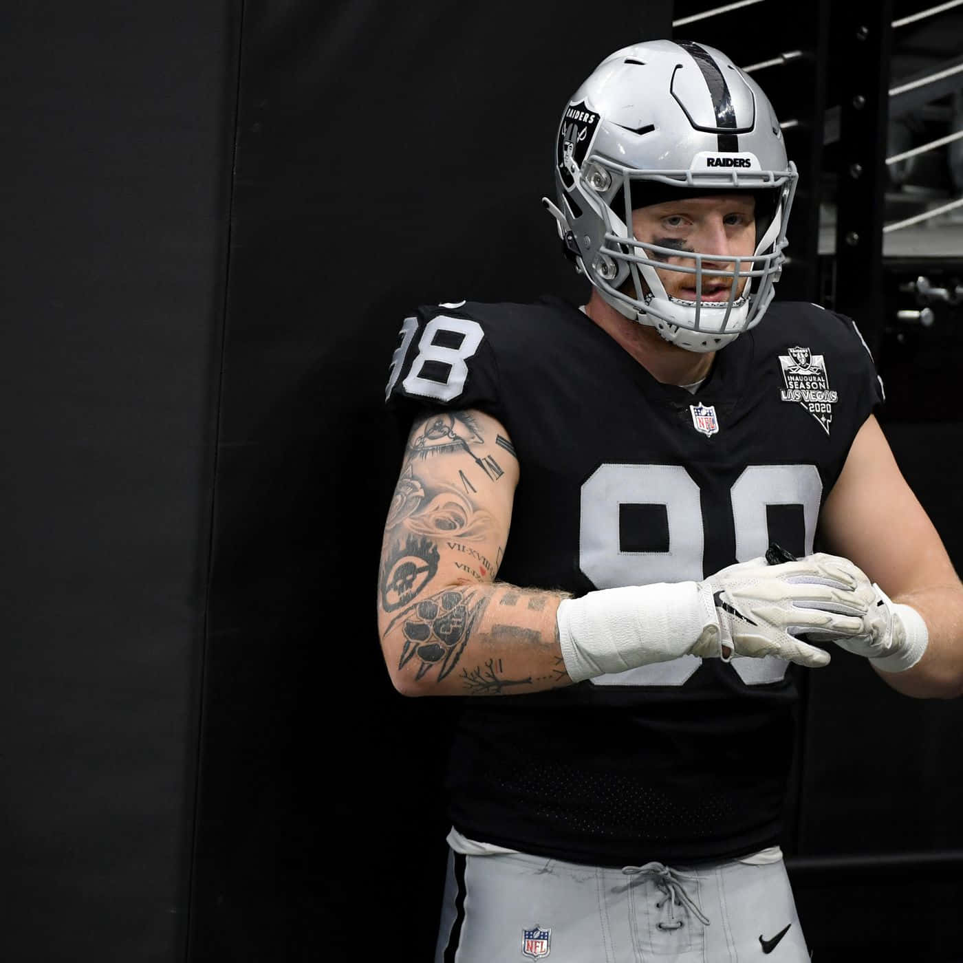 身穿 Raiders 球衣的足球員在更衣室裡展示紋身