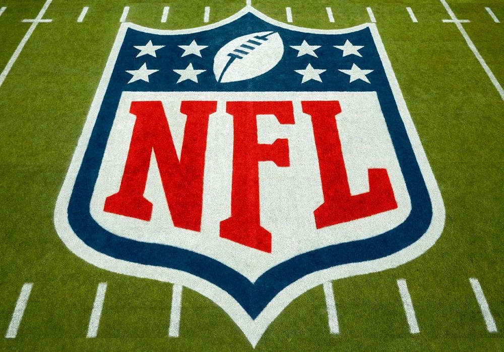 NFL標誌繪製在綠色足球場草地上，帶有白色碼線。