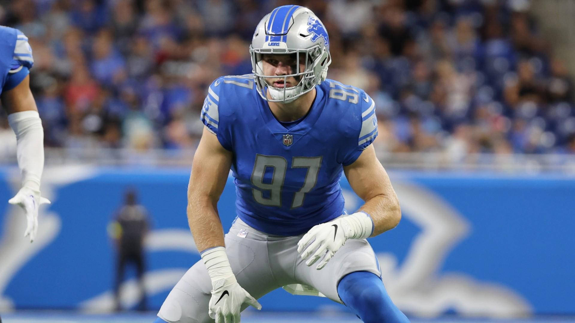 NFL季前賽底特律獵鷹隊艾丹·哈欽遜 壁紙 — 一名底特律雄獅隊的足球員身穿藍銀色制服，在比賽中於球場上激烈蹲伏。