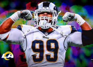 NFL球員 亞倫·唐納德 肌肉展示高畫質 壁紙 — 一名身穿白色公羊隊球衣的足球運動員在充滿活力的抽象背景前展示肌肉。