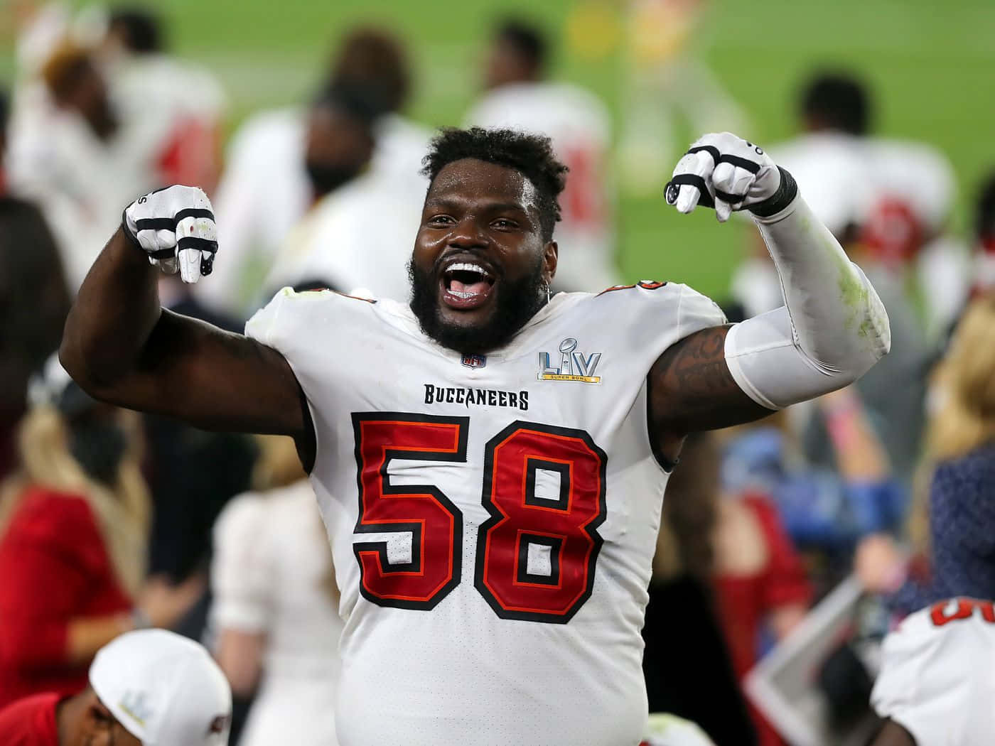 NFL球員沙奎爾·巴雷特 坦帕灣海盜隊 壁紙 — 一位身穿白色58號球衣的坦帕灣海盜隊美式足球員，在燈光球場上高舉雙臂慶祝勝利。