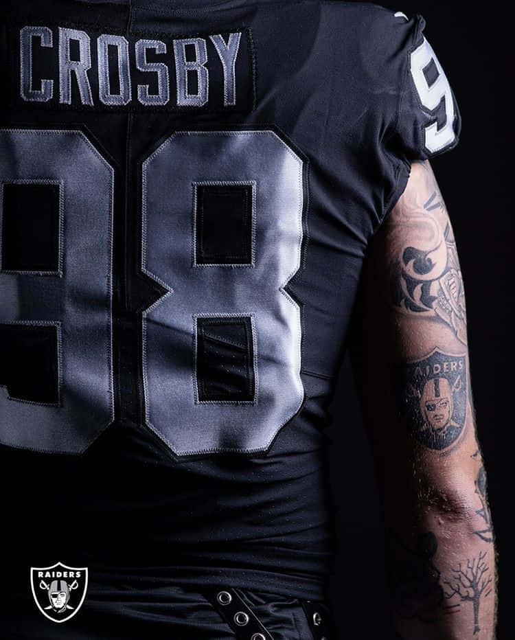 黑色Raiders足球球衣背面，號碼98和名字Crosby，顯示有紋身的手臂。