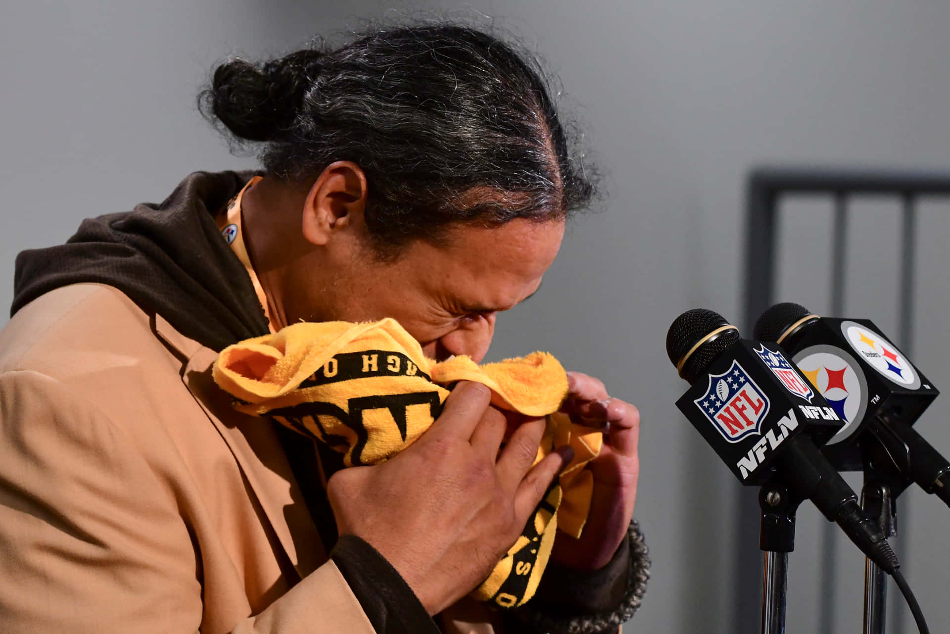 男子在NFL記者會上將臉埋在鋼人隊毛巾中哭泣。