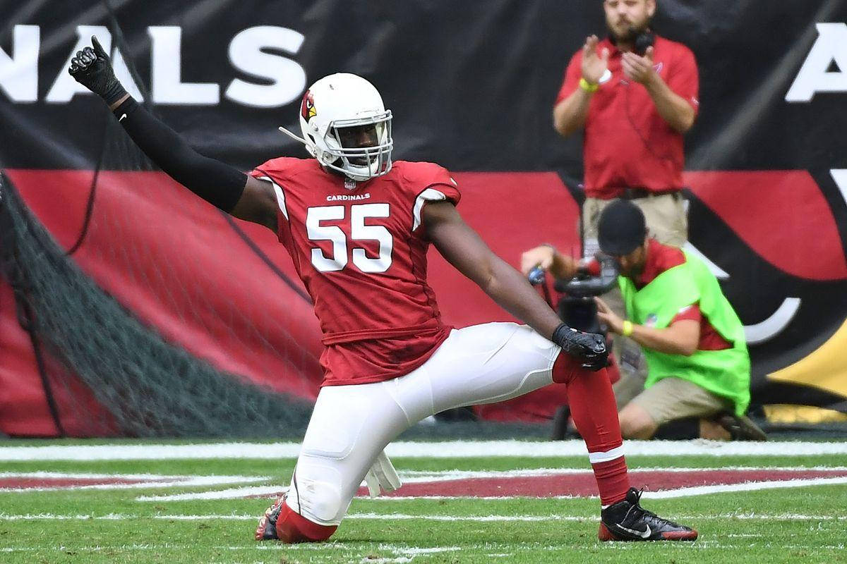 身穿紅色 Cardinals 球衣的美式足球員在場上慶祝。