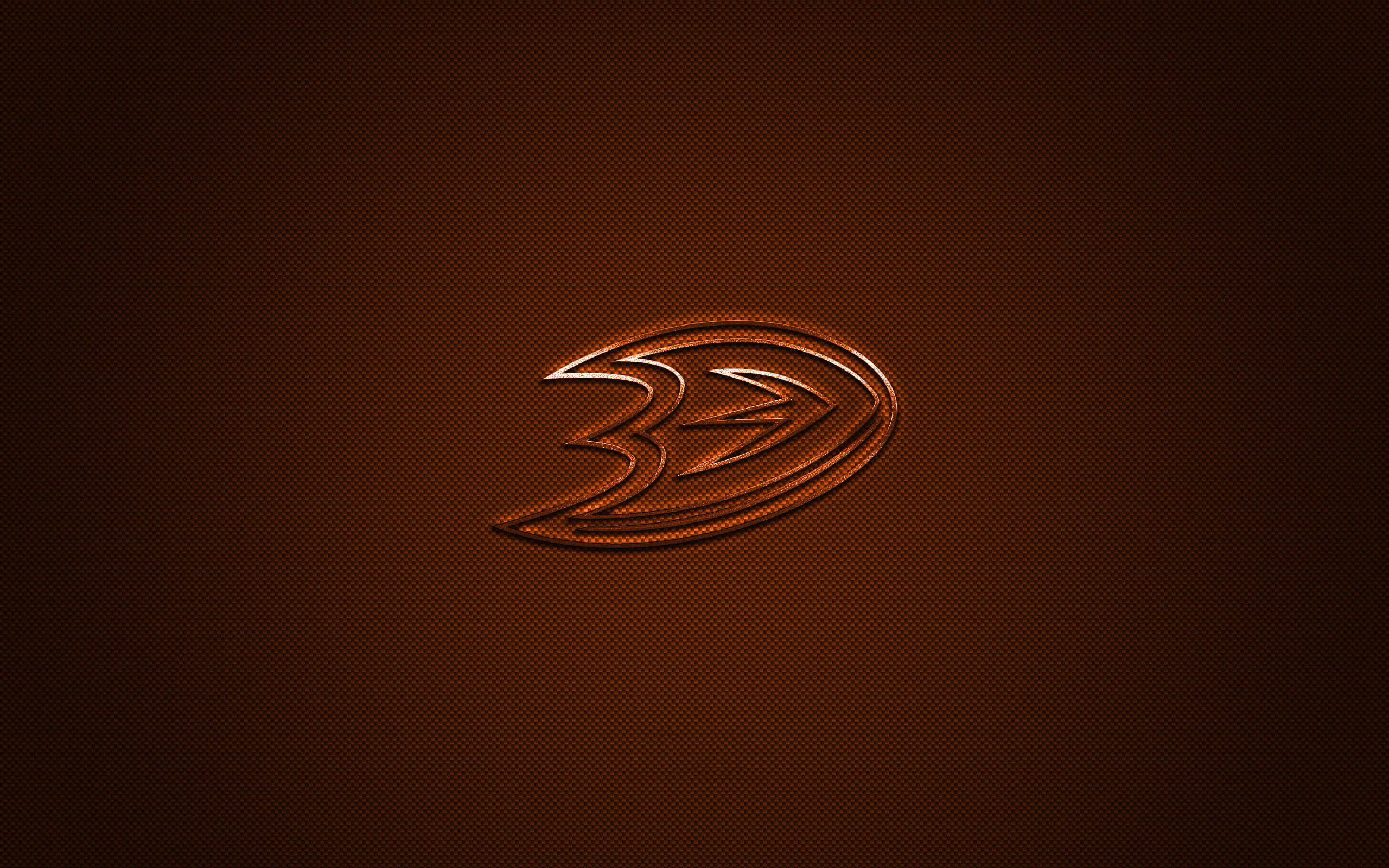 NHL安那罕鴨隊碳纖維設計 壁紙 — 一個發光的橙色安納海姆鴨隊標誌，居中放置在帶有細微漸變照明的紋理深棕色背景上。