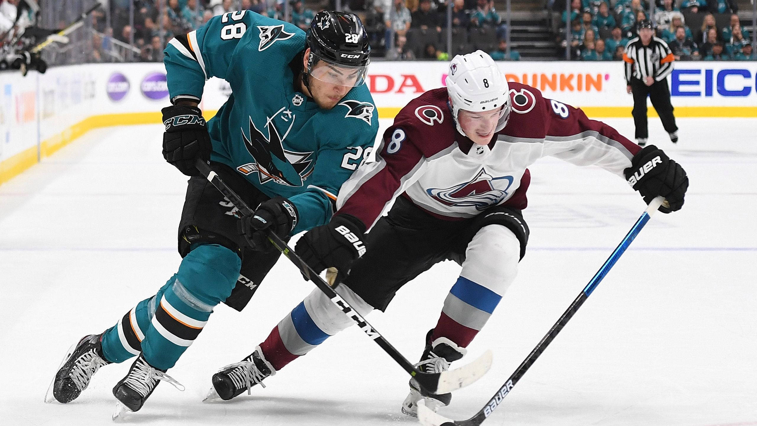 NHL球星高強度對決；卡爾·馬卡爾對決蒂莫·梅耶 壁紙 — 兩名曲棍球運動員在光線明亮的冰場上激烈爭奪控球權，進行一場職業比賽。
