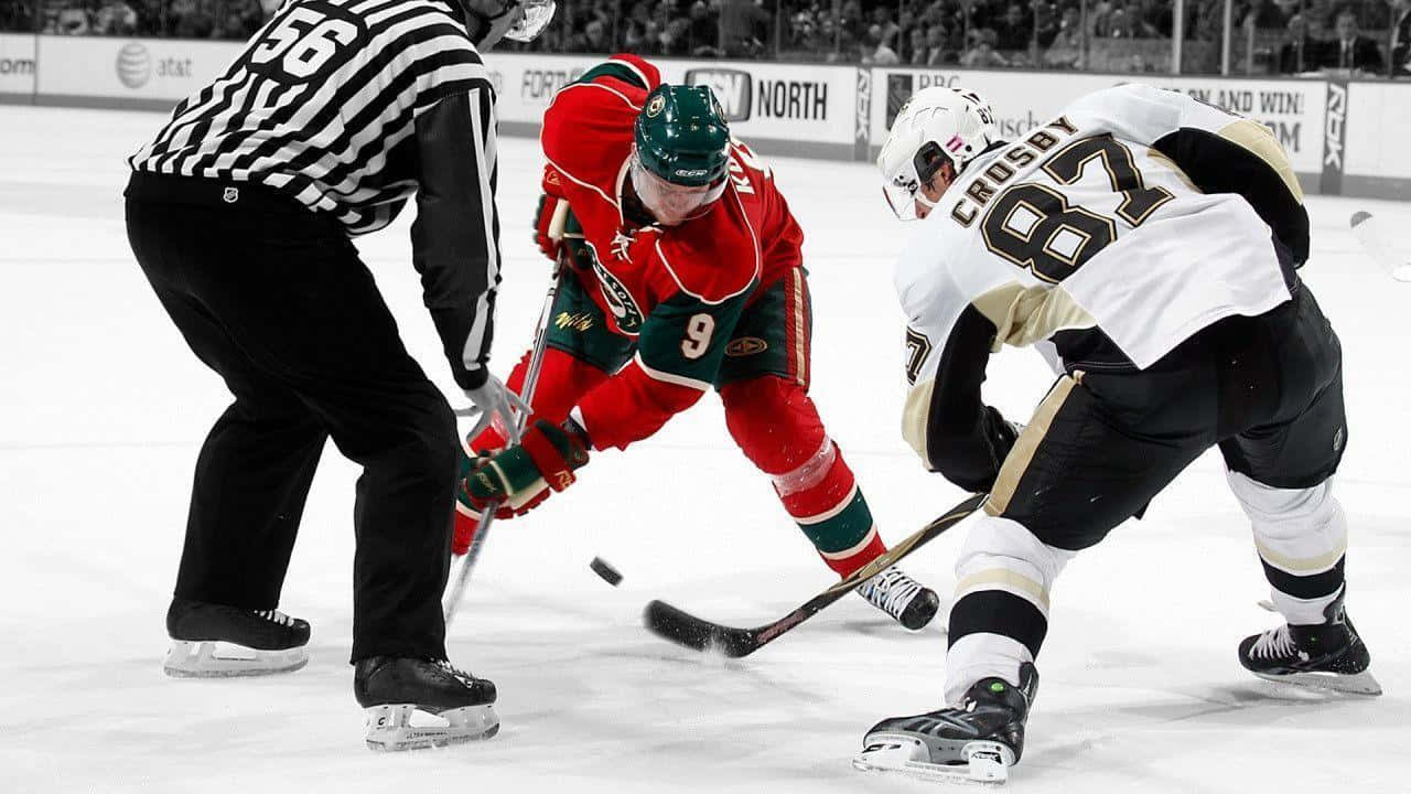 NHL聯盟標誌 壁紙 — 兩名曲棍球運動員在冰上爭奪冰球，裁判在旁密切注視。