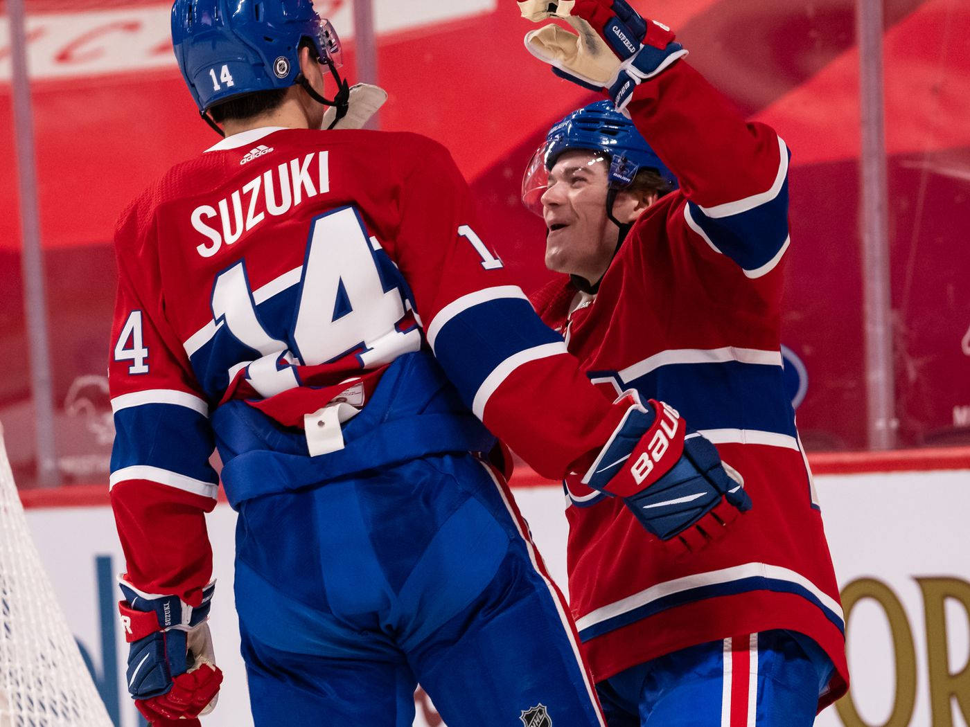 NHL 職業球員 尼克·蘇茲與科爾·卡菲爾德 壁紙 — 兩名身穿紅色和藍色球衣的冰球運動員在冰上擊掌慶祝入球。