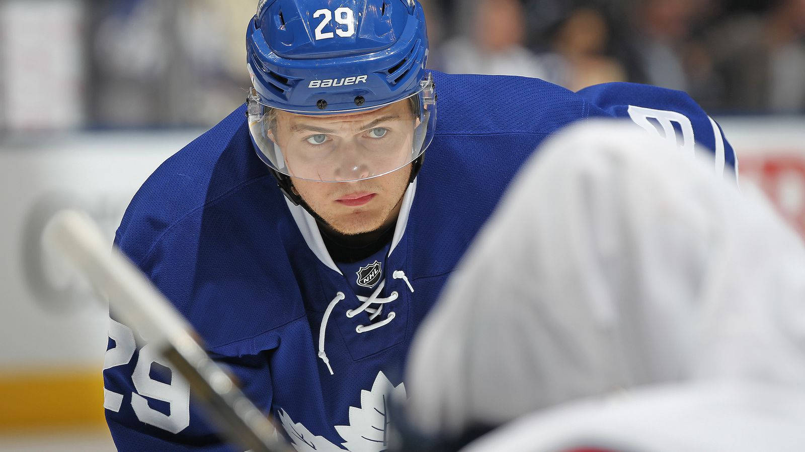 NHL球星威廉·尼蘭德比賽中 壁紙 — 一名專注的曲棍球運動員身穿藍色多倫多楓葉隊球衣，在比賽中於冰上向前傾身。