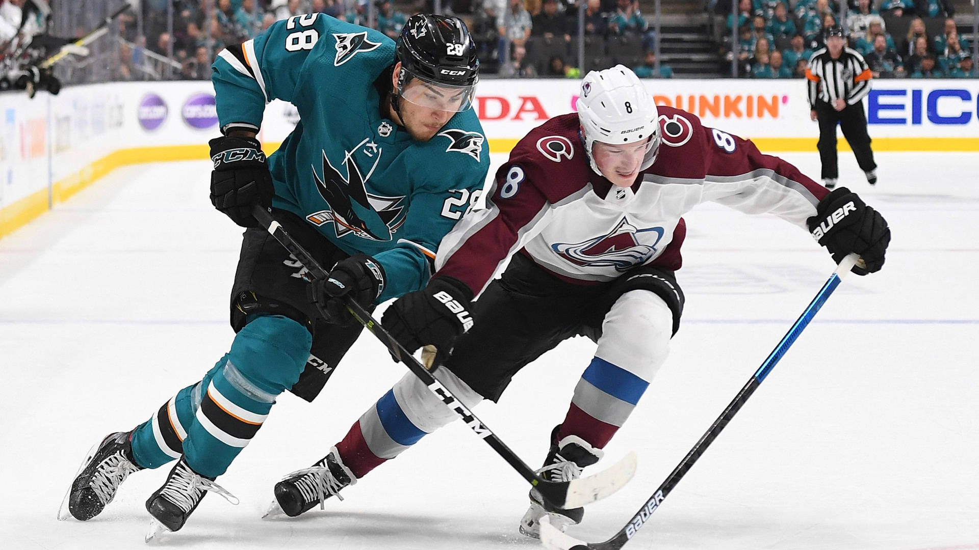 NHL球星高強度對決；卡爾·馬卡爾對決蒂莫·梅耶 壁紙 — 兩名曲棍球運動員在光線明亮的冰場上激烈爭奪控球權，進行一場職業比賽。