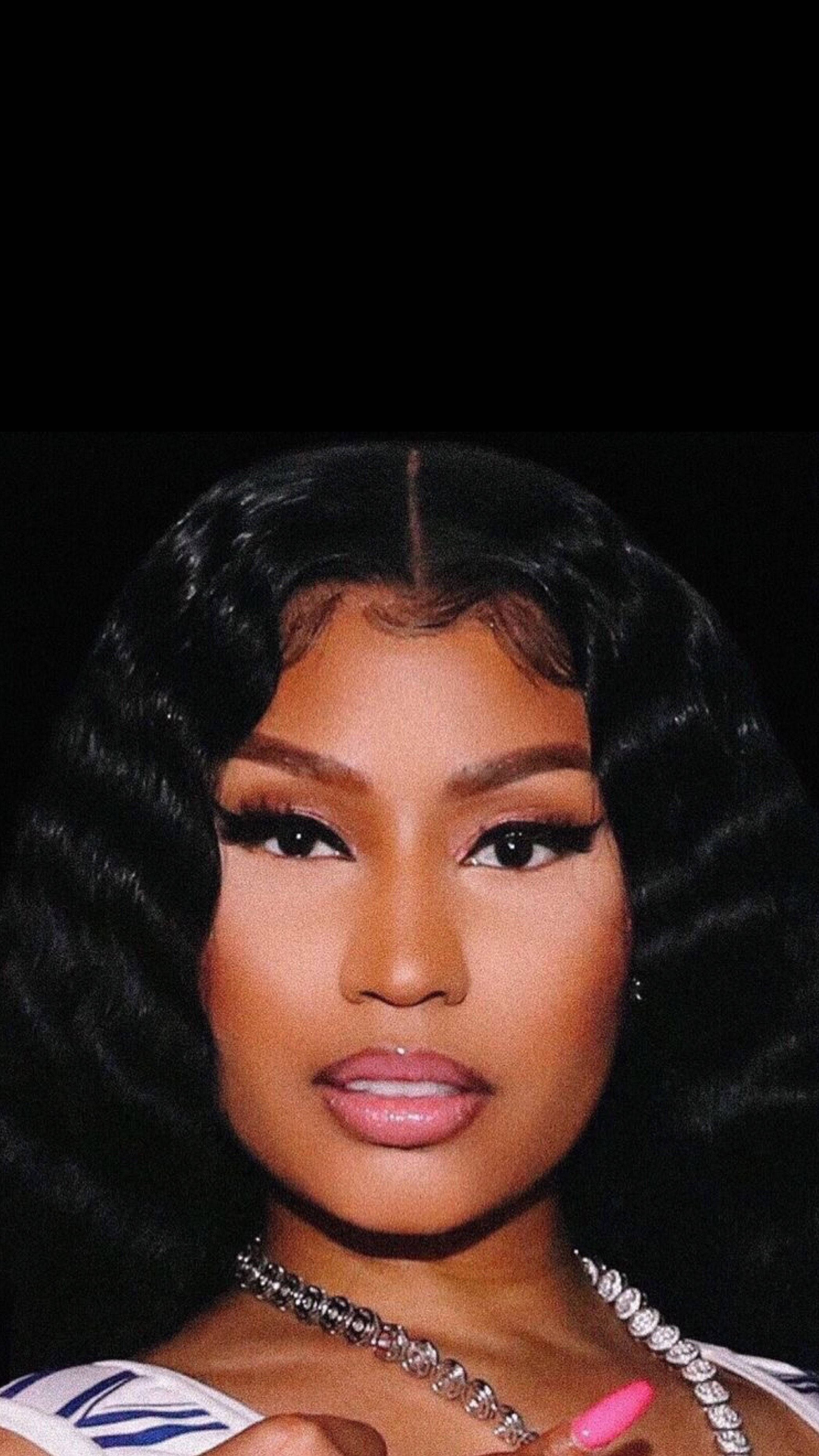 Nicki Minaj 近距離特寫 壁紙 — 一位擁有豐盈黑色捲髮和大膽妝容的女性，在純黑背景下的迷人肖像。