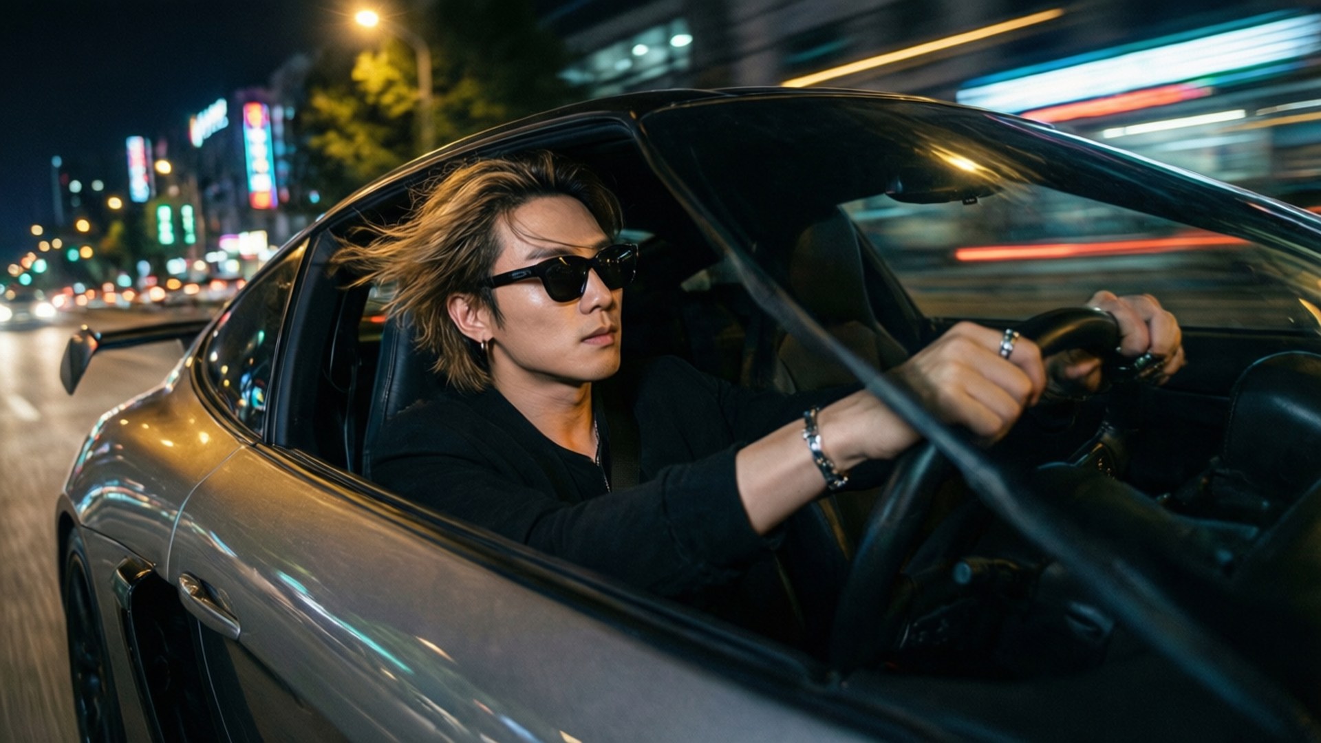 戴太陽眼鏡的男士在夜晚駕駛銀色跑車穿過霓虹城市