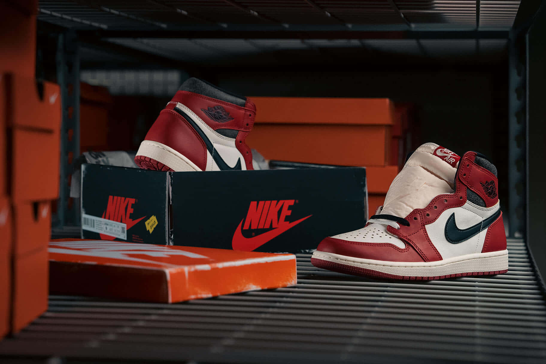 紅、白、黑色Nike Air Jordan 1運動鞋放在金屬架上，旁邊有品牌鞋盒。