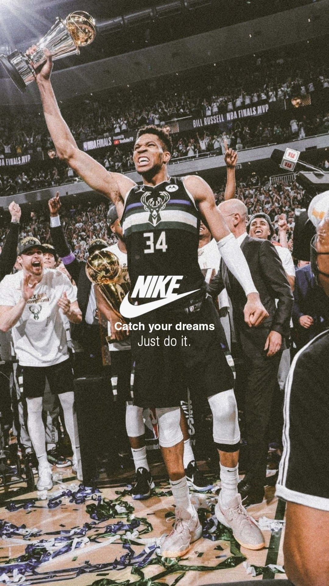 以Nike籃球釋放您的全部潛能 壁紙 — 一名身穿黑色34號球衣的籃球運動員在佈滿五彩紙屑的球場上高舉冠軍獎盃，慶祝勝利。