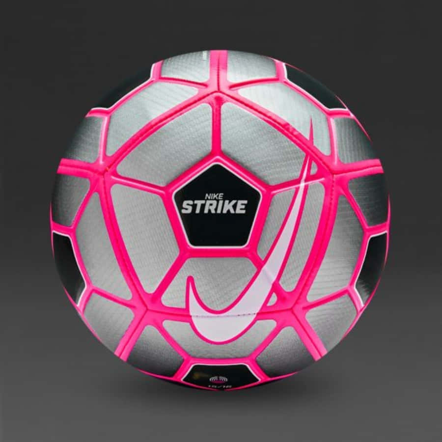 Pink Soccer Ball 桌布 壁紙 — Nike Strike 足球特寫，銀色面板配以鮮豔粉紅色縫線，背景為深灰色。