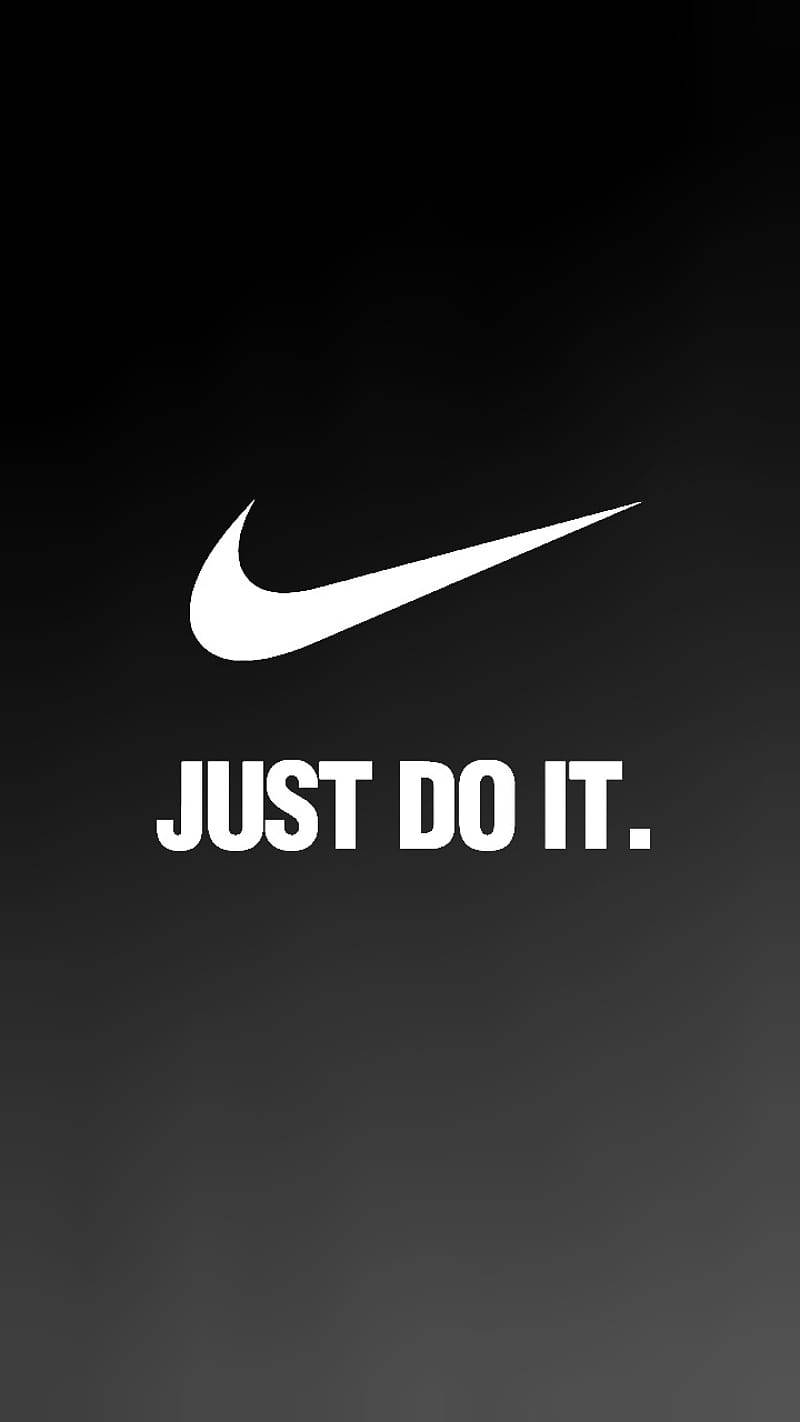 Nike Swoosh標誌與Just Do It 壁紙 — 大膽的白色Nike勾勾和「JUST DO IT.」標語居中於漸變黑色背景上。