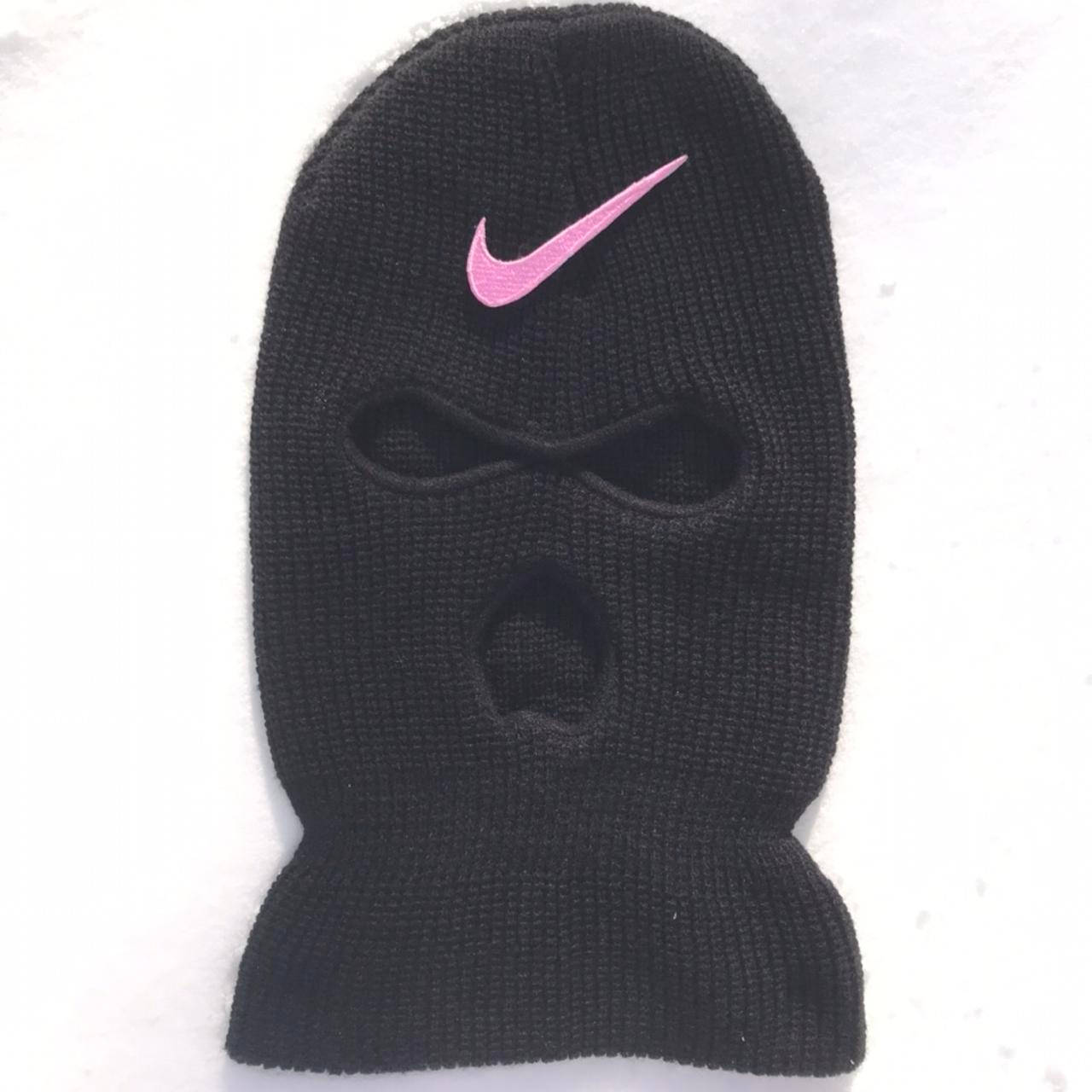 白色背景上帶有粉紅色Nike標誌的黑色針織滑雪面罩。
