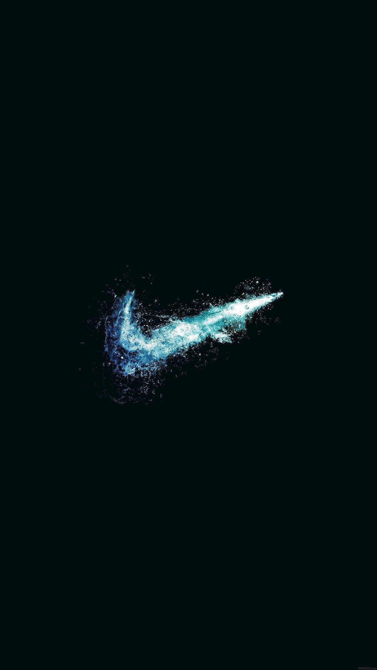Nike鞋標誌 壁紙 — 在純黑背景下，發光的藍色Nike Swoosh標誌從粒子爆發中浮現。